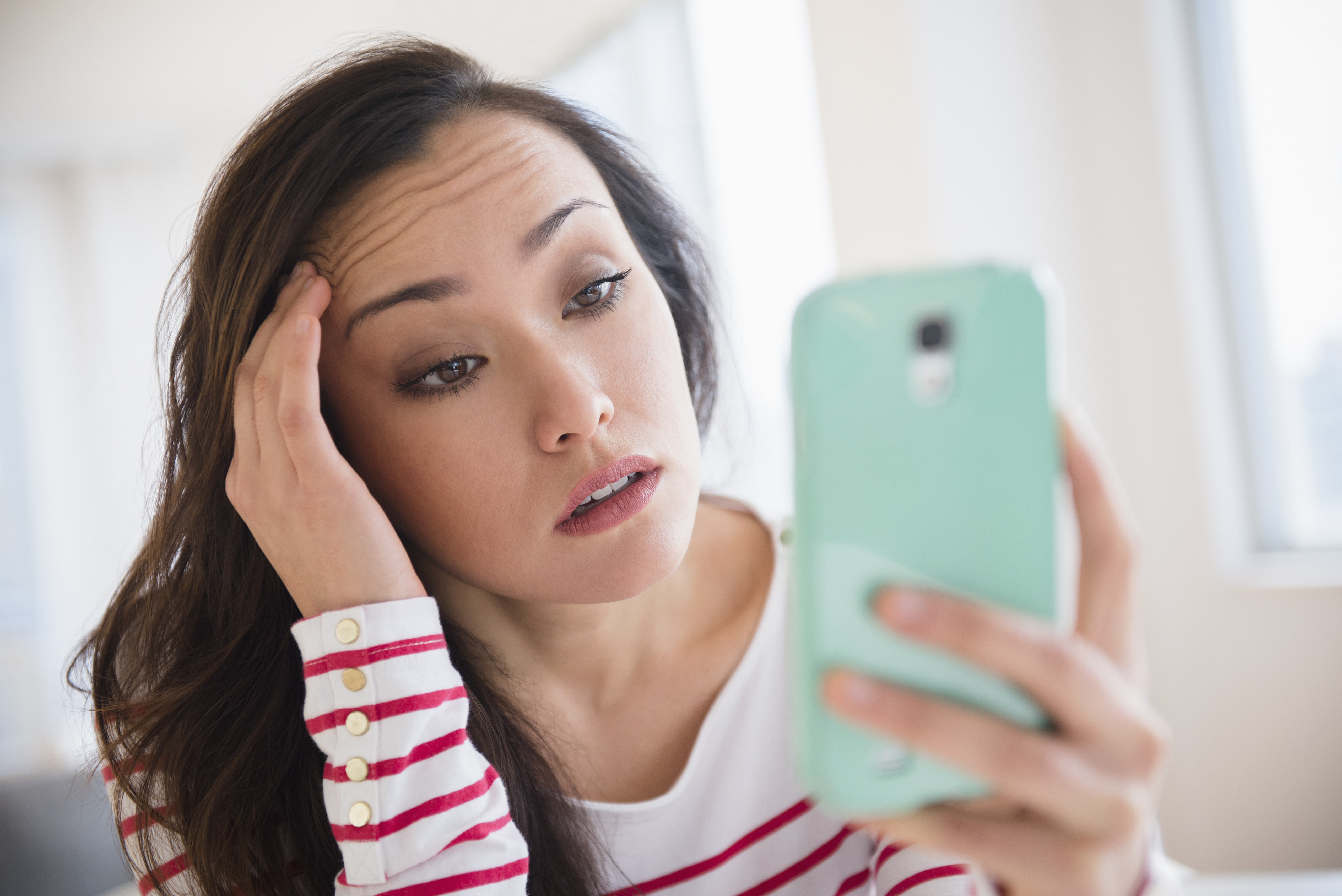 Jeune femme stressée regardant son téléphone | Source : Getty Images