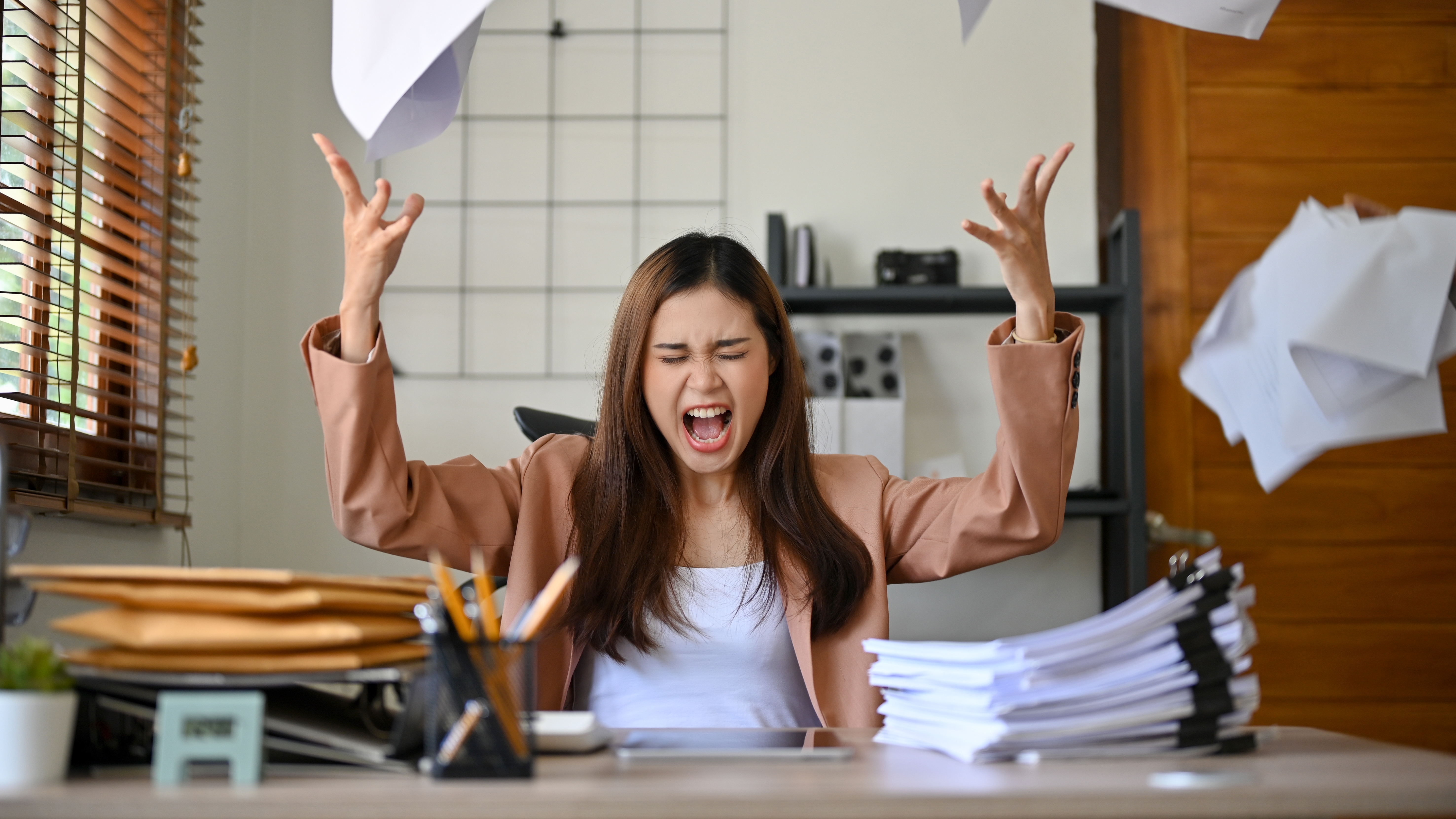 Une femme jetant des papiers en l'air en signe de colère. | Source : Shutterstock/Bongkar Graphic