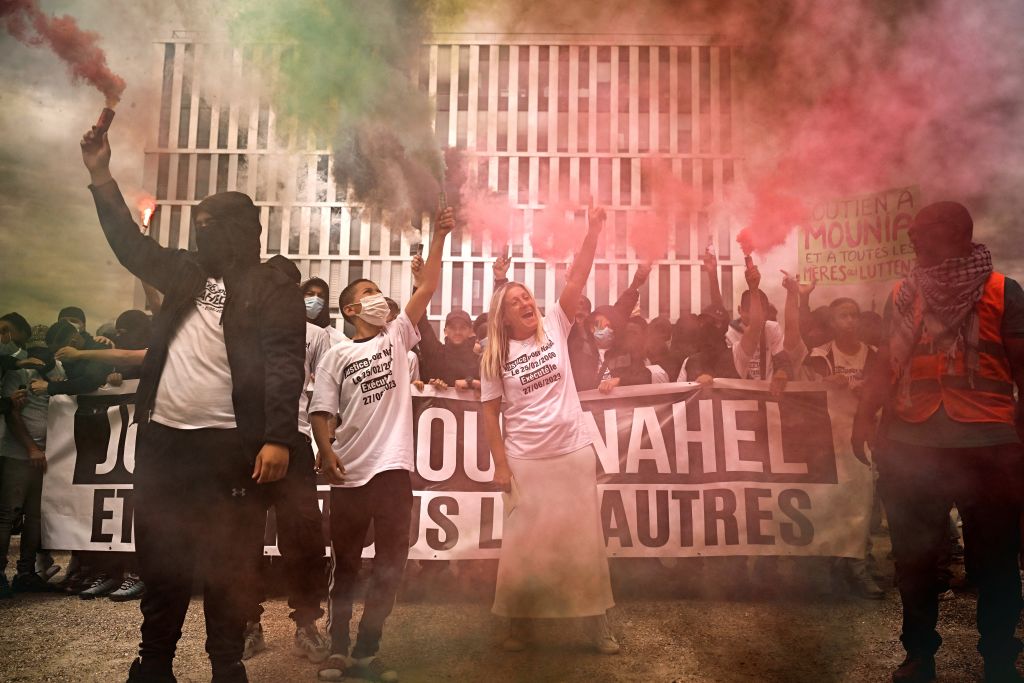 Mounia - la mère de Nahel, un jeune homme de 17 ans qui a été tué d'une balle dans la poitrine par la police à bout portant en 2023 - se tient dans la fumée des fusées éclairantes allumées alors qu'elle s'adresse aux participants à un rassemblement à Nanterre, dans la banlieue ouest de Paris, le 29 juin 2024, organisé en hommage à son fils.(Photo by JULIEN DE ROSA / AFP) (Photo by JULIEN DE ROSA/AFP via Getty Images