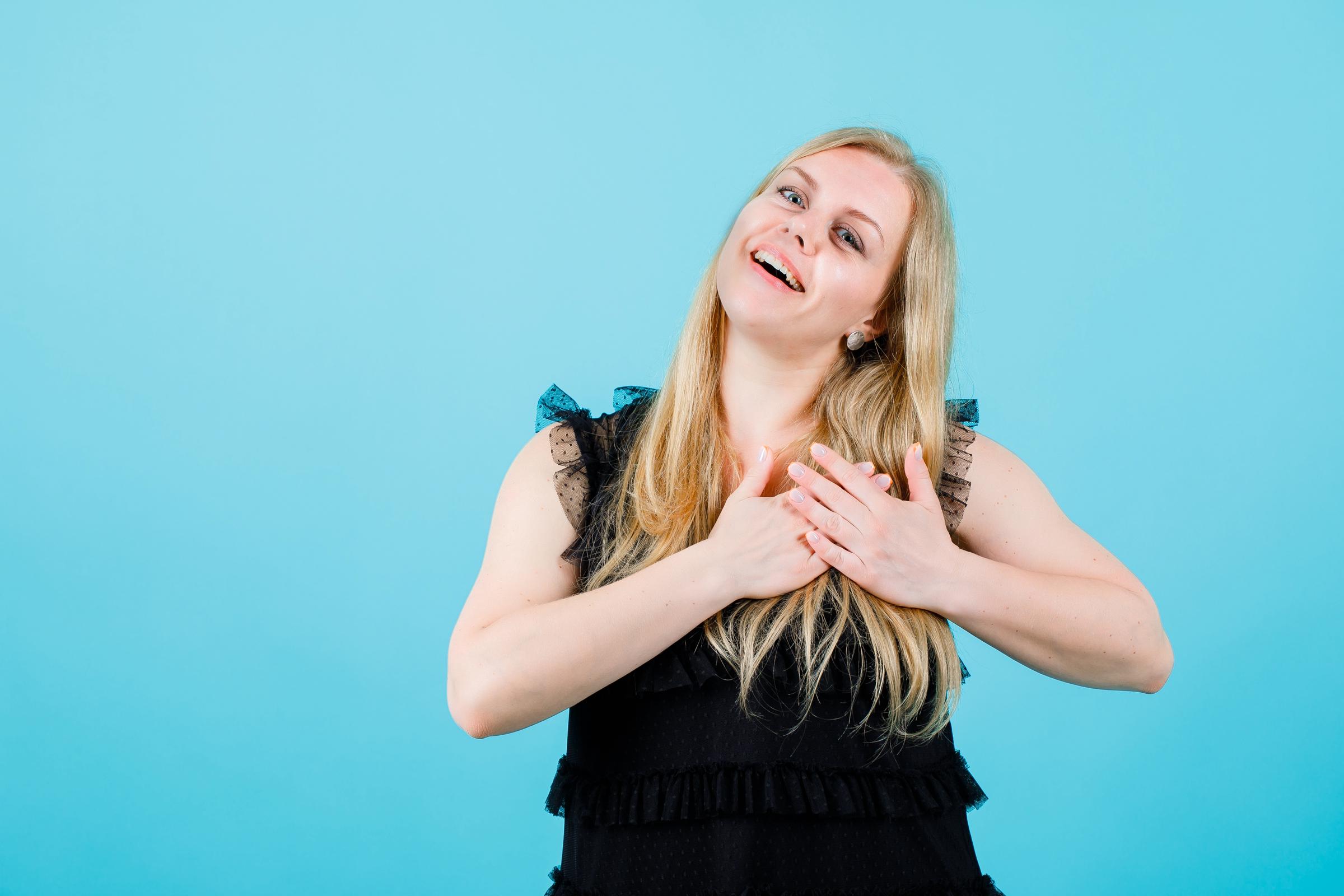 Une femme faisant un vœu, les mains sur le cœur | Source : Freepik