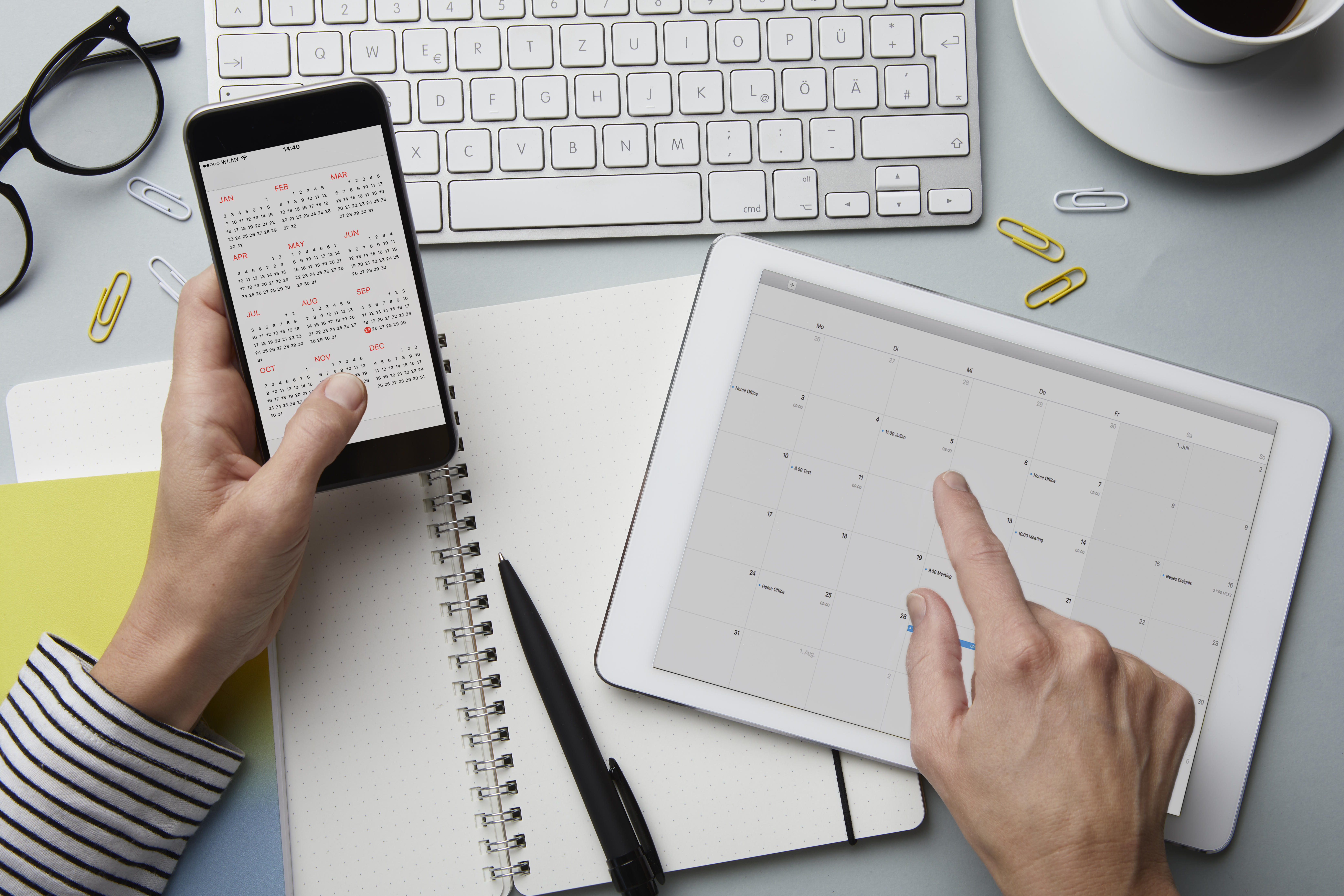 Une personne avec un smartphone et une tablette en train de programmer sa journée | Source : Getty Images
