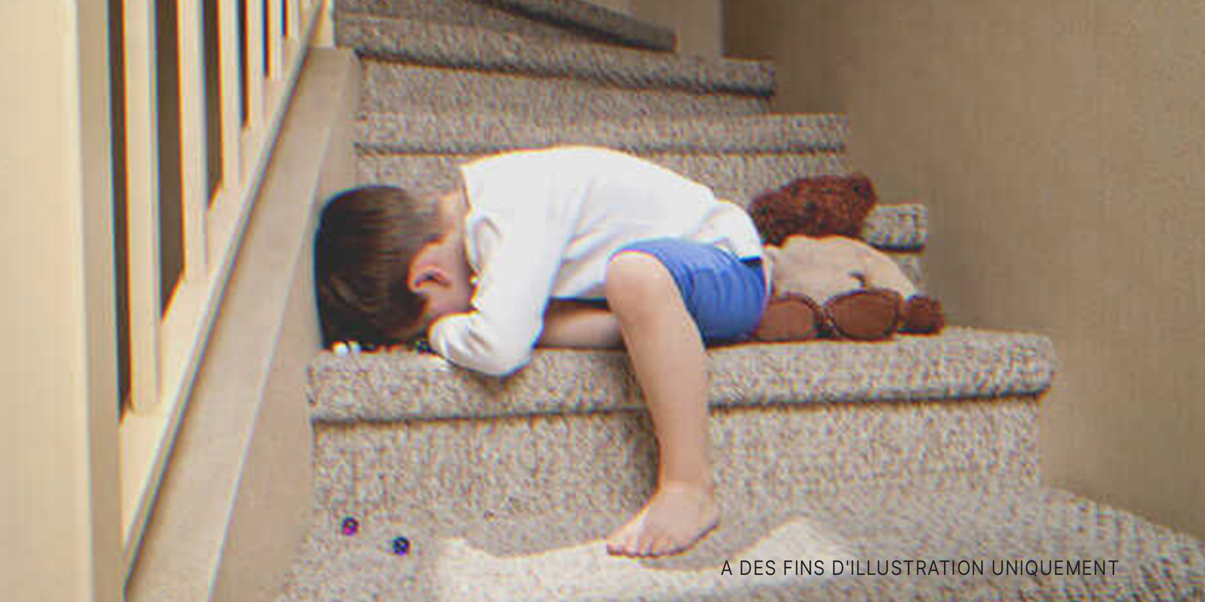 Un garçon pleurant dans les escaliers d'une maison | Source : Shutterstock