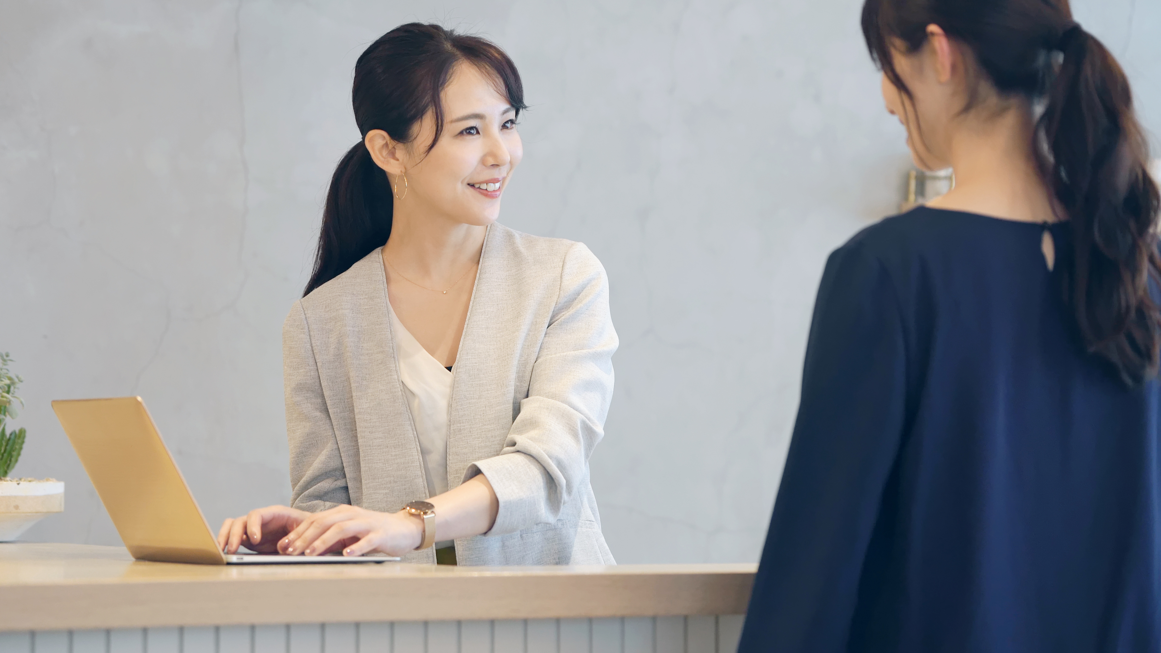 Une femme parle à une réceptionniste asiatique | Source : Shutterstock