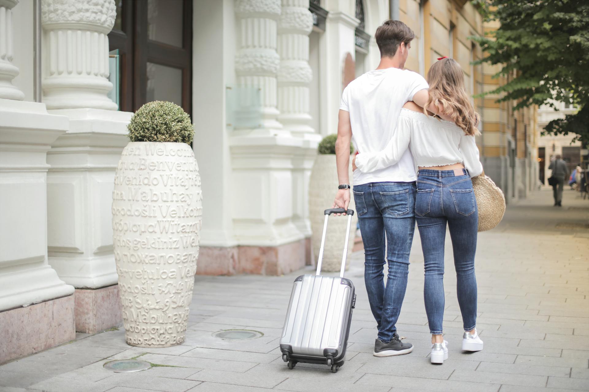 Couple avec une valise marchant dans la rue | Source : Pexels