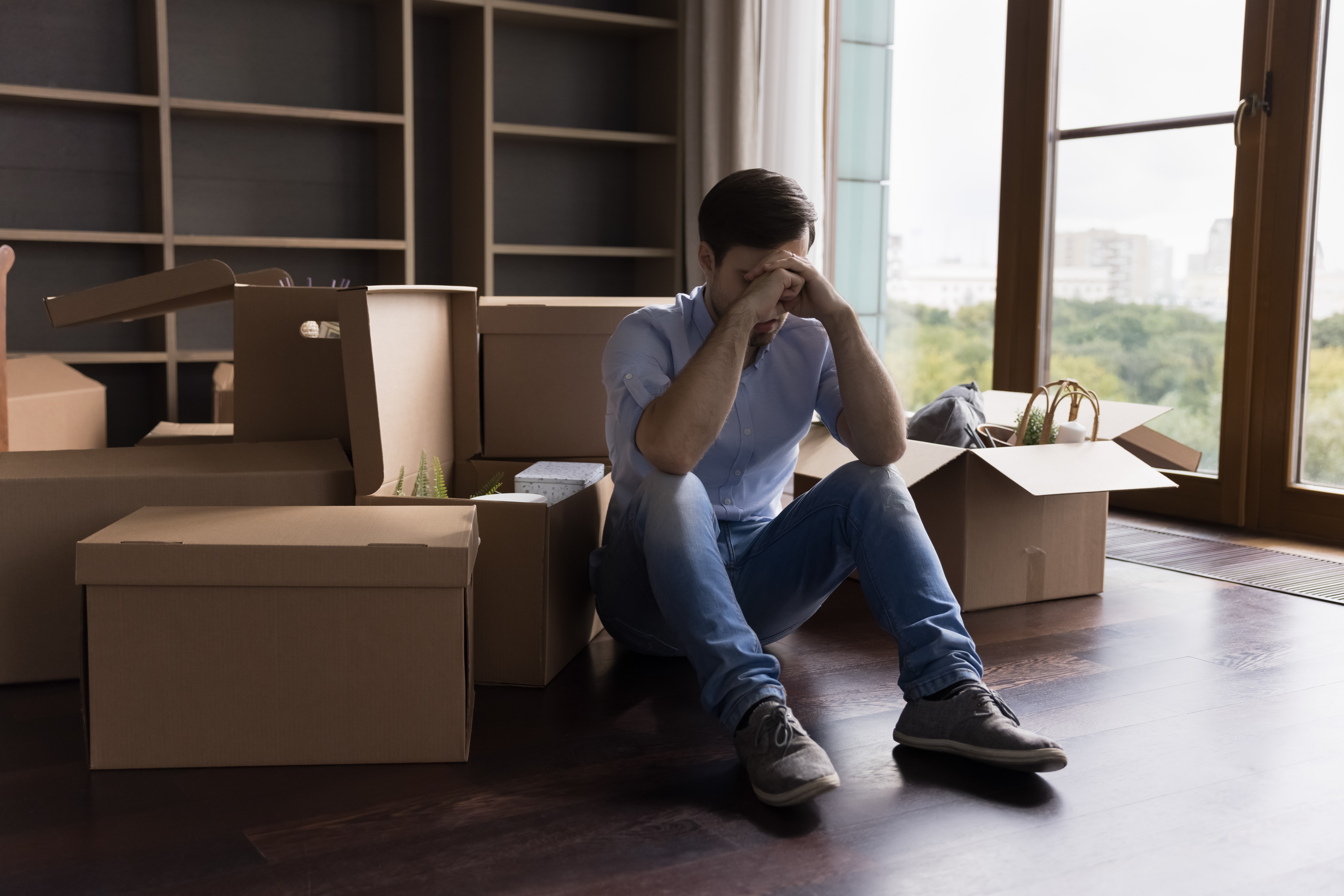 Un jeune homme frustré entouré de cartons de déménagement | Source : Shutterstock