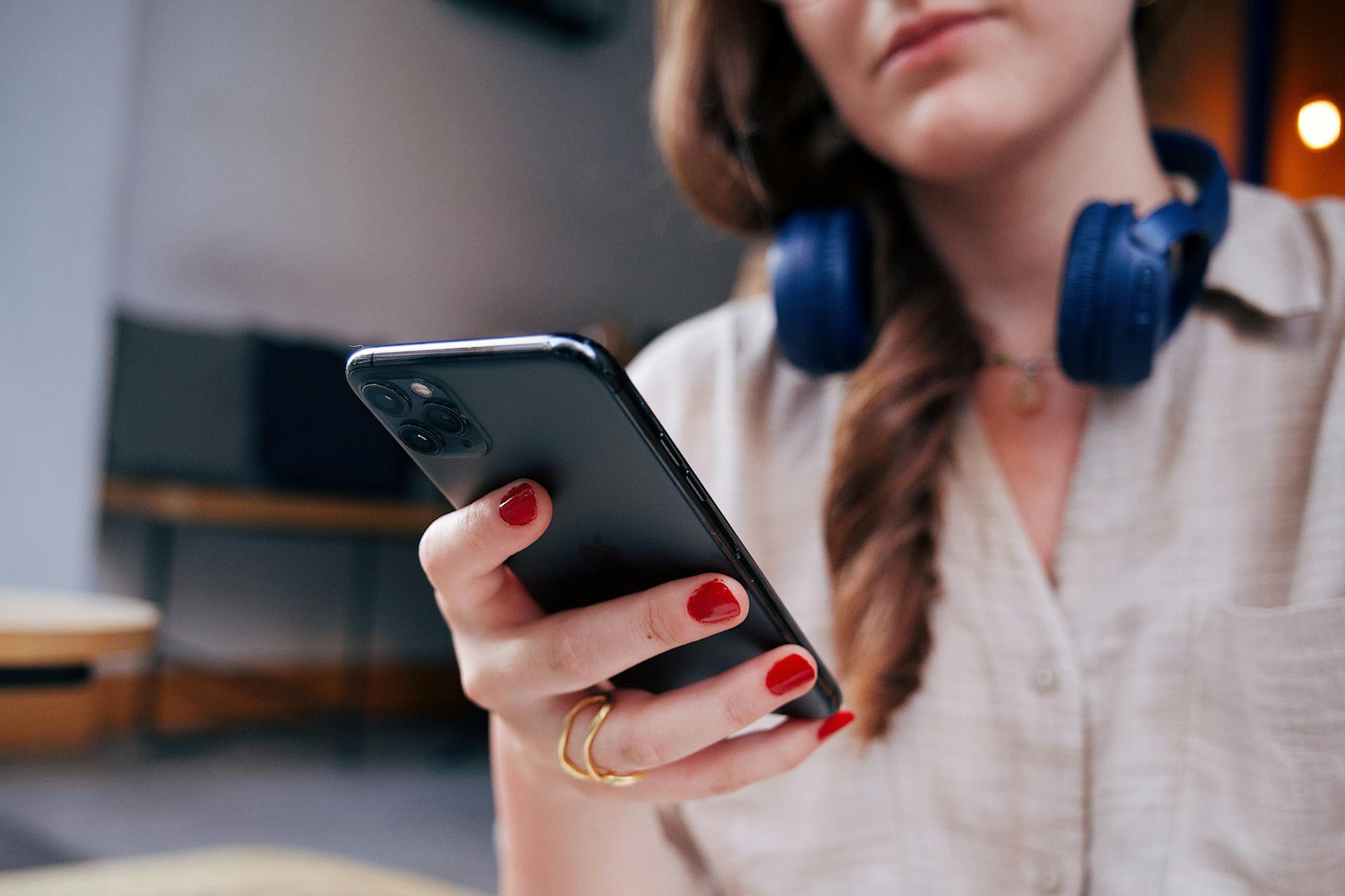 Une femme souriante qui regarde son téléphone | Source : Pexels