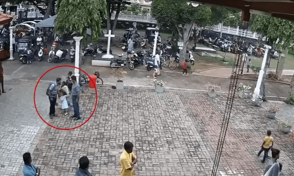 Le bombardier présumé de l'attentat touche la tête d'une petite fille devant le temple de San Sebastian à Negombo, au Sri Lanka | Photo : Hindustan Times/YouTube