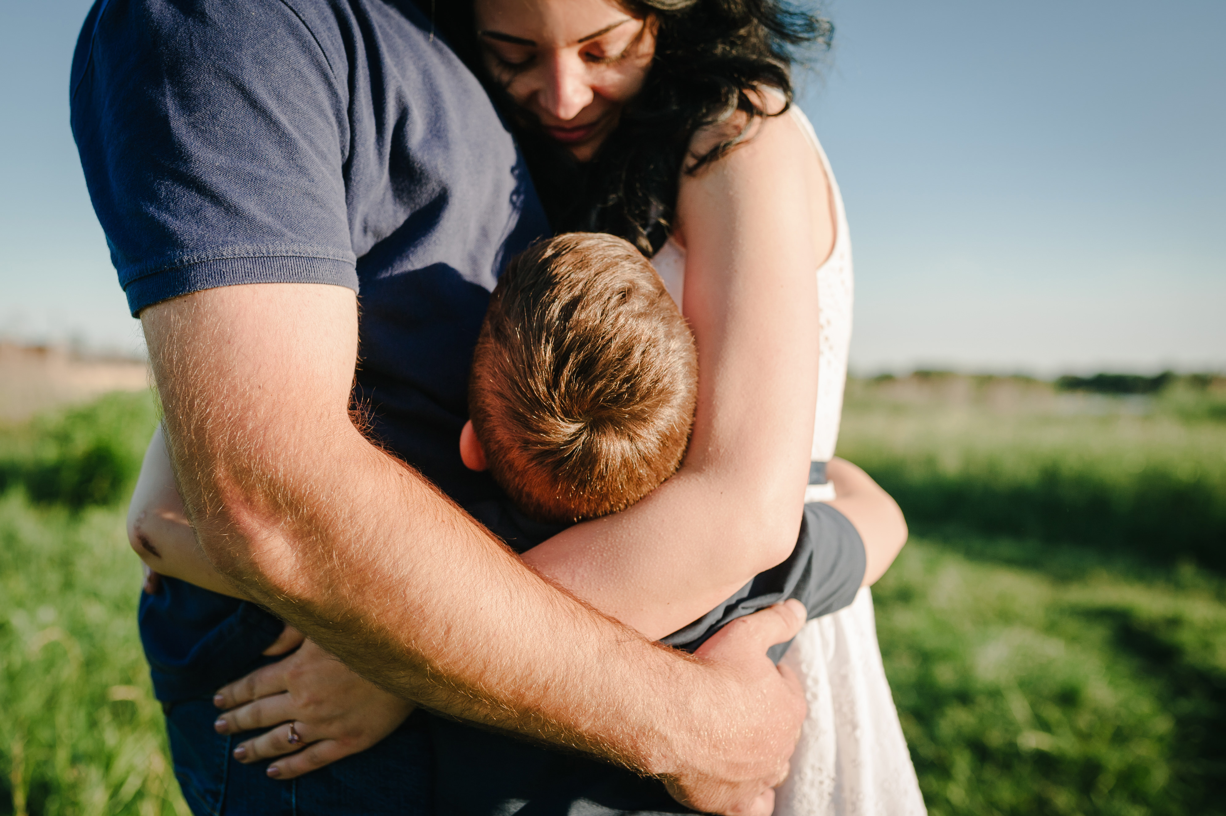 Niño abraza a sus padres | Fuente: Shutterstock.com