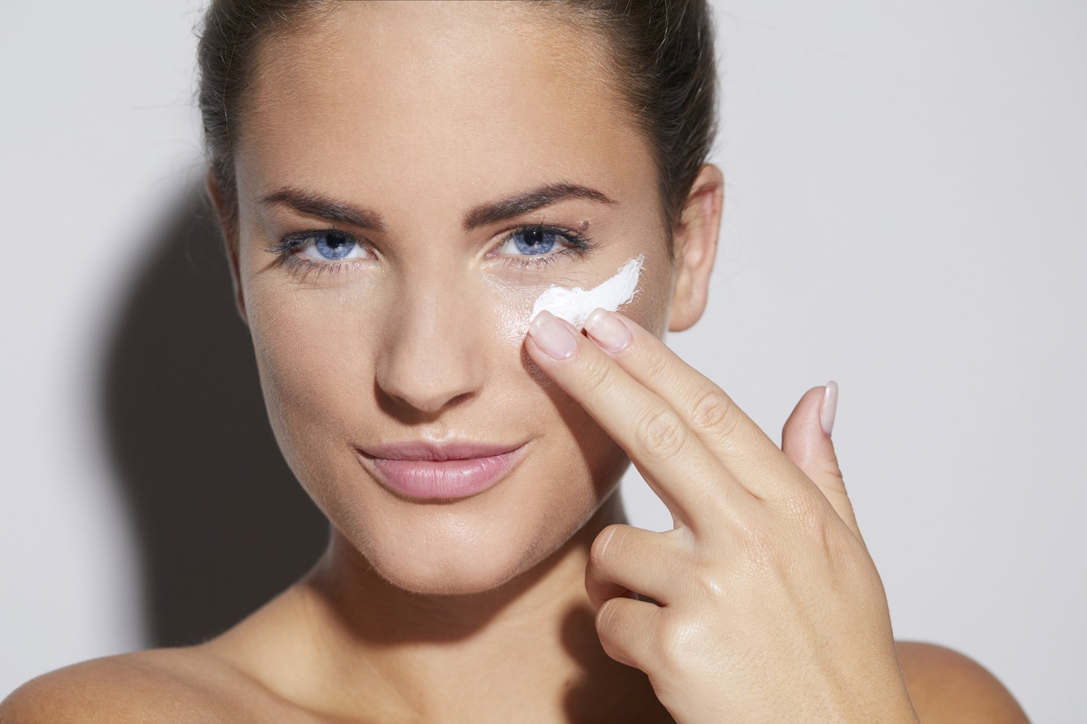 Une femme applique une crème sur son visage. | Photo : Getty Images