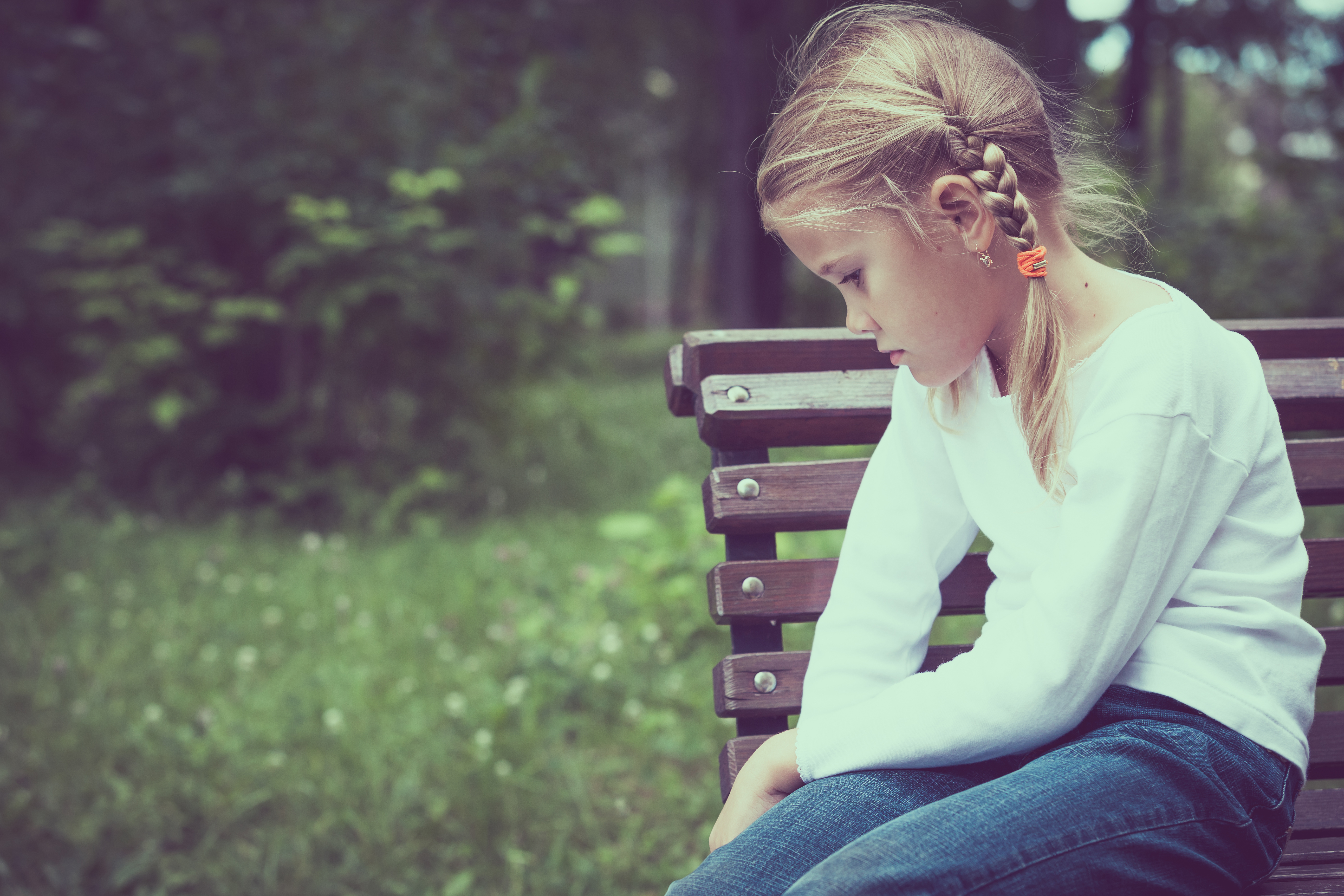 Une petite fille assise sur un banc | Source : Shutterstock