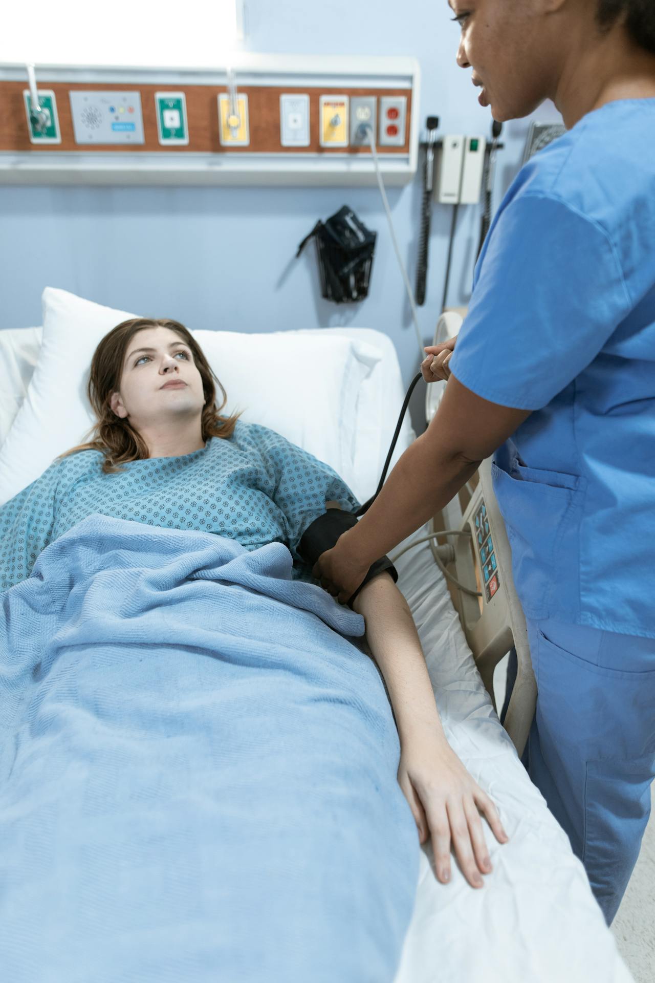 Une femme allongée dans un lit d'hôpital et regardant l'infirmière | Source : Pexels