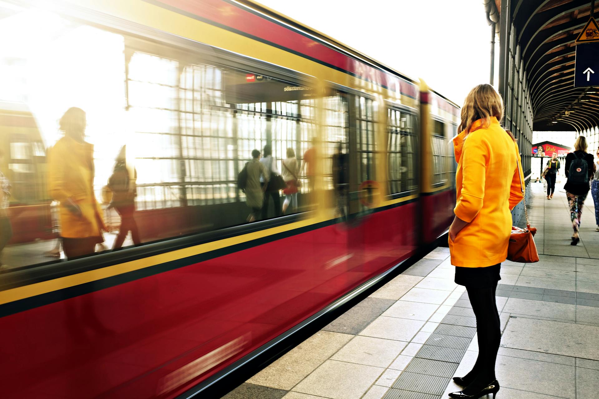 Une femme debout à côté d'un train rouge | Source : Pexels