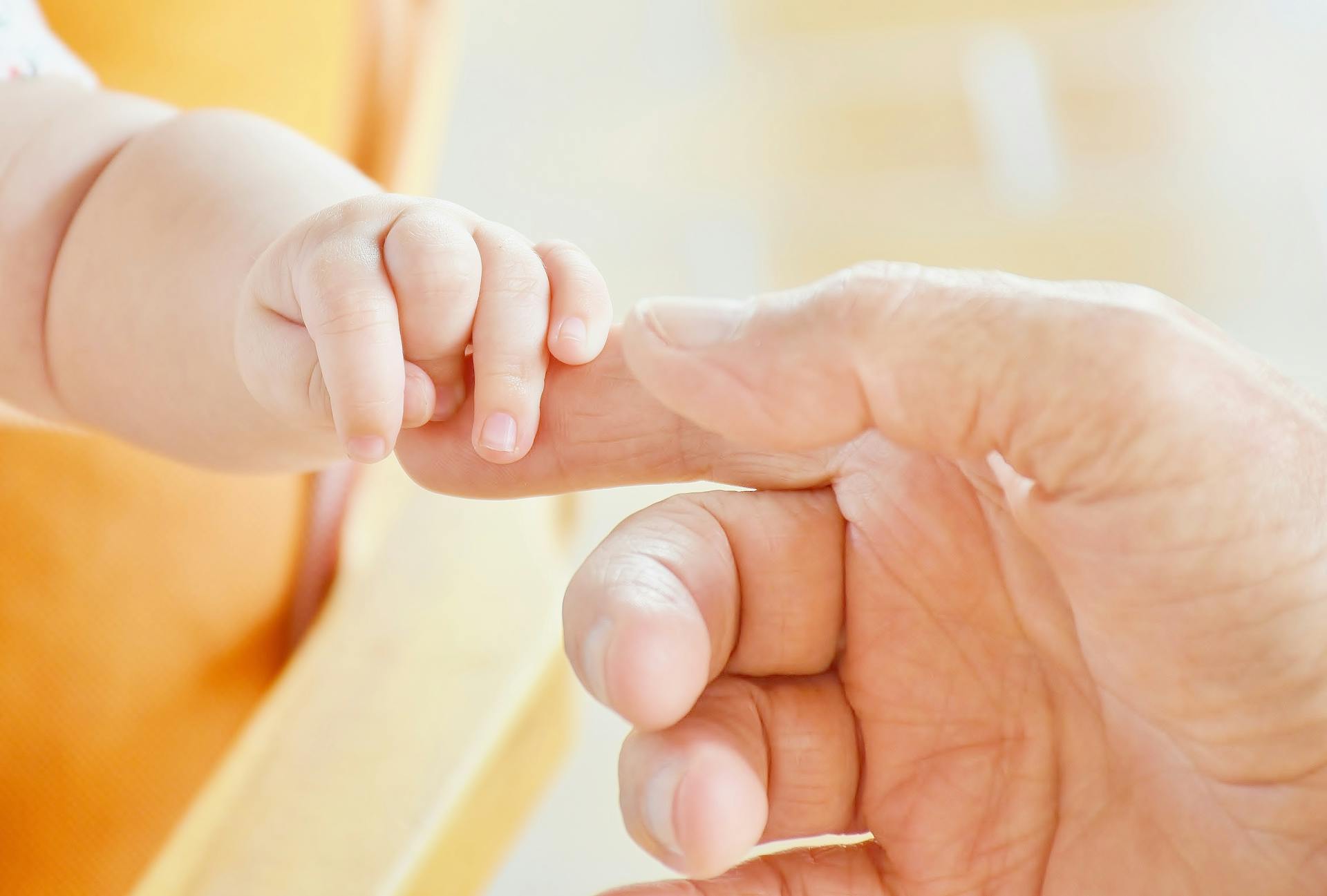 Un bébé tenant le doigt d'un homme | Source : Pexels