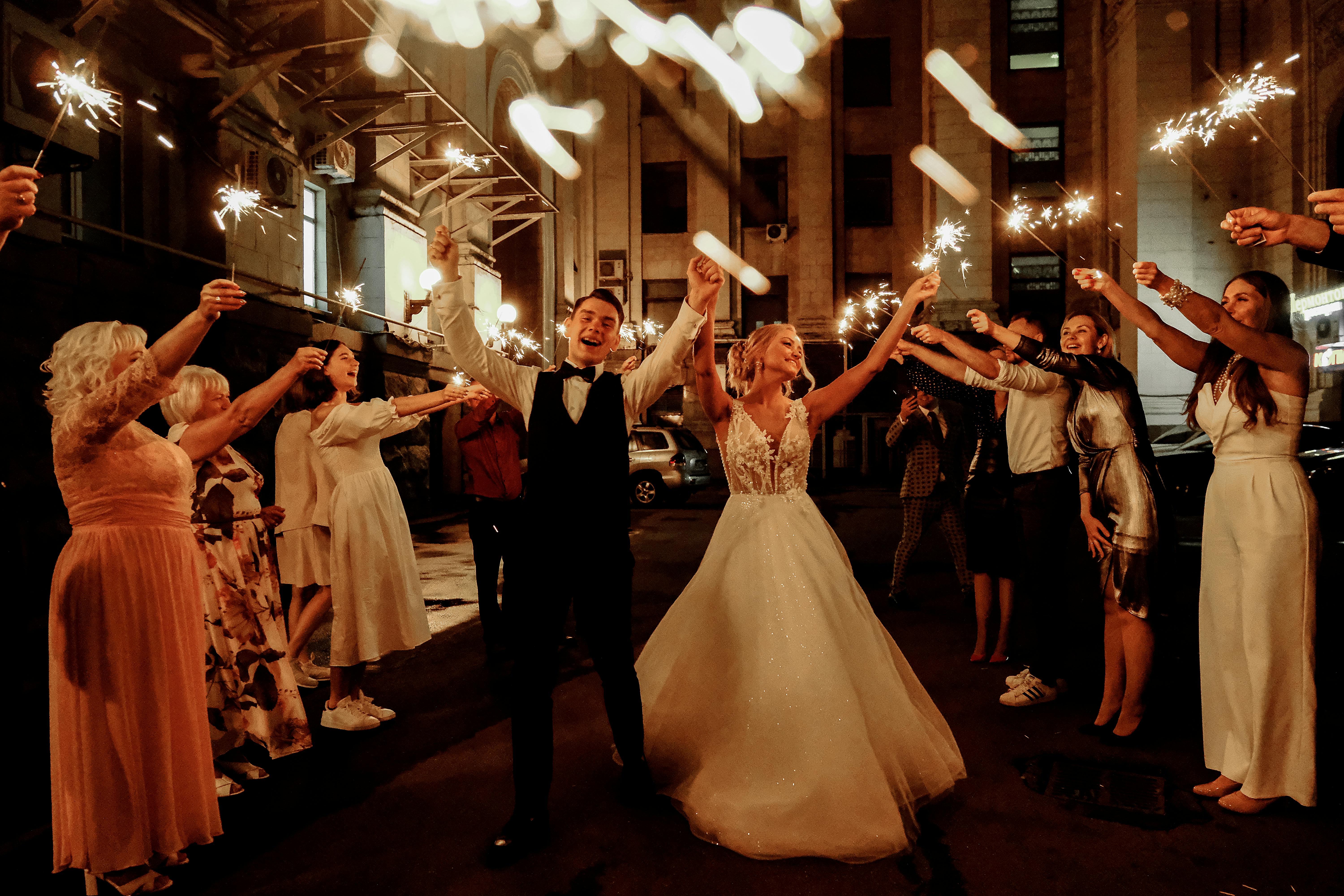 Des invités et un couple de jeunes mariés célèbrent le mariage dans la nuit | Source : Pexels