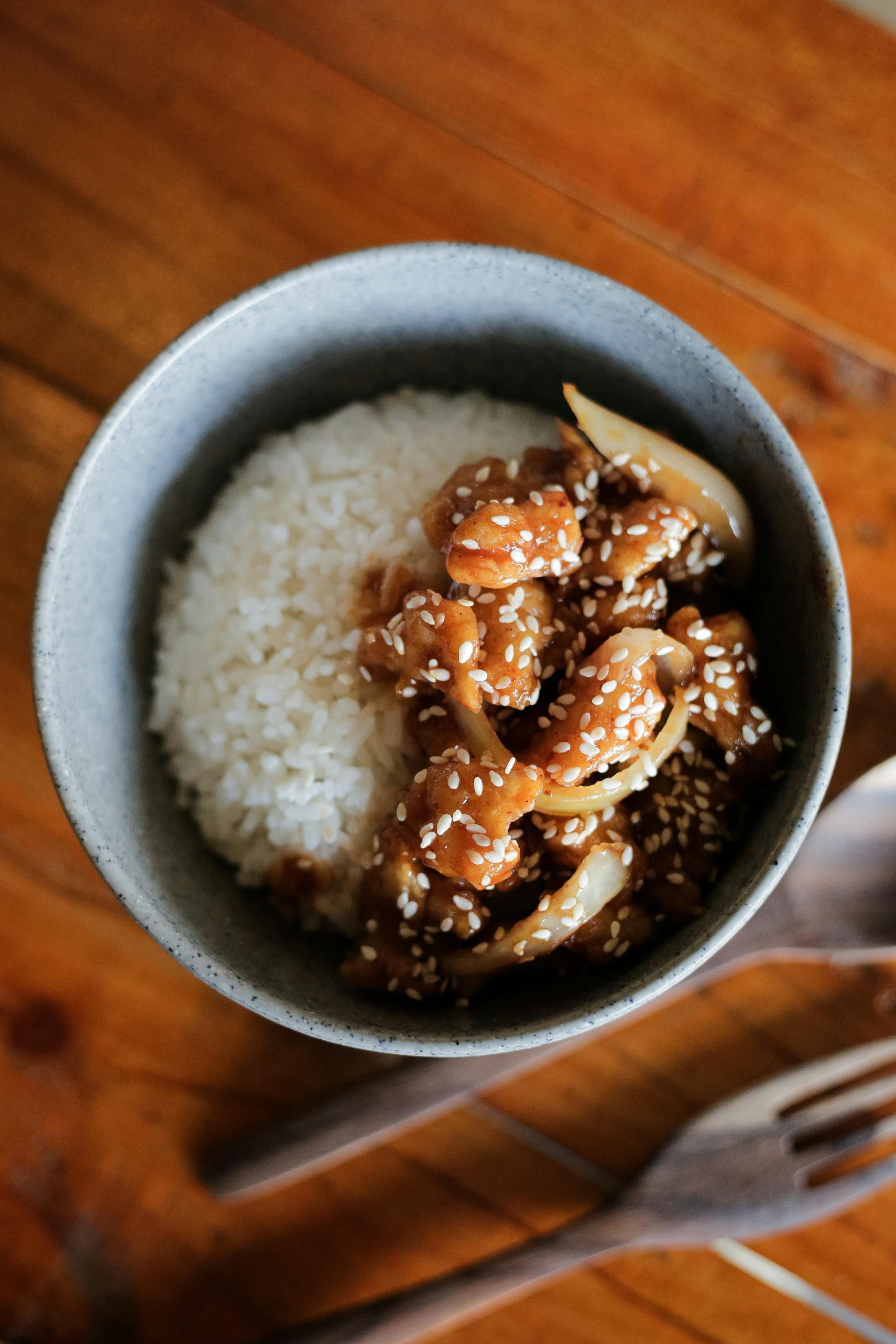 Un bol de poulet au sésame avec du riz | Source : Pexels