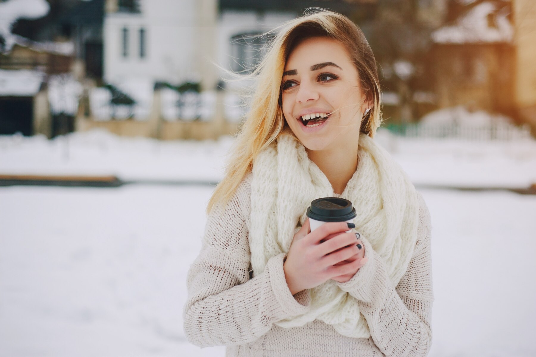 Une femme souriante à l'extérieur en hiver | Source : Freepik