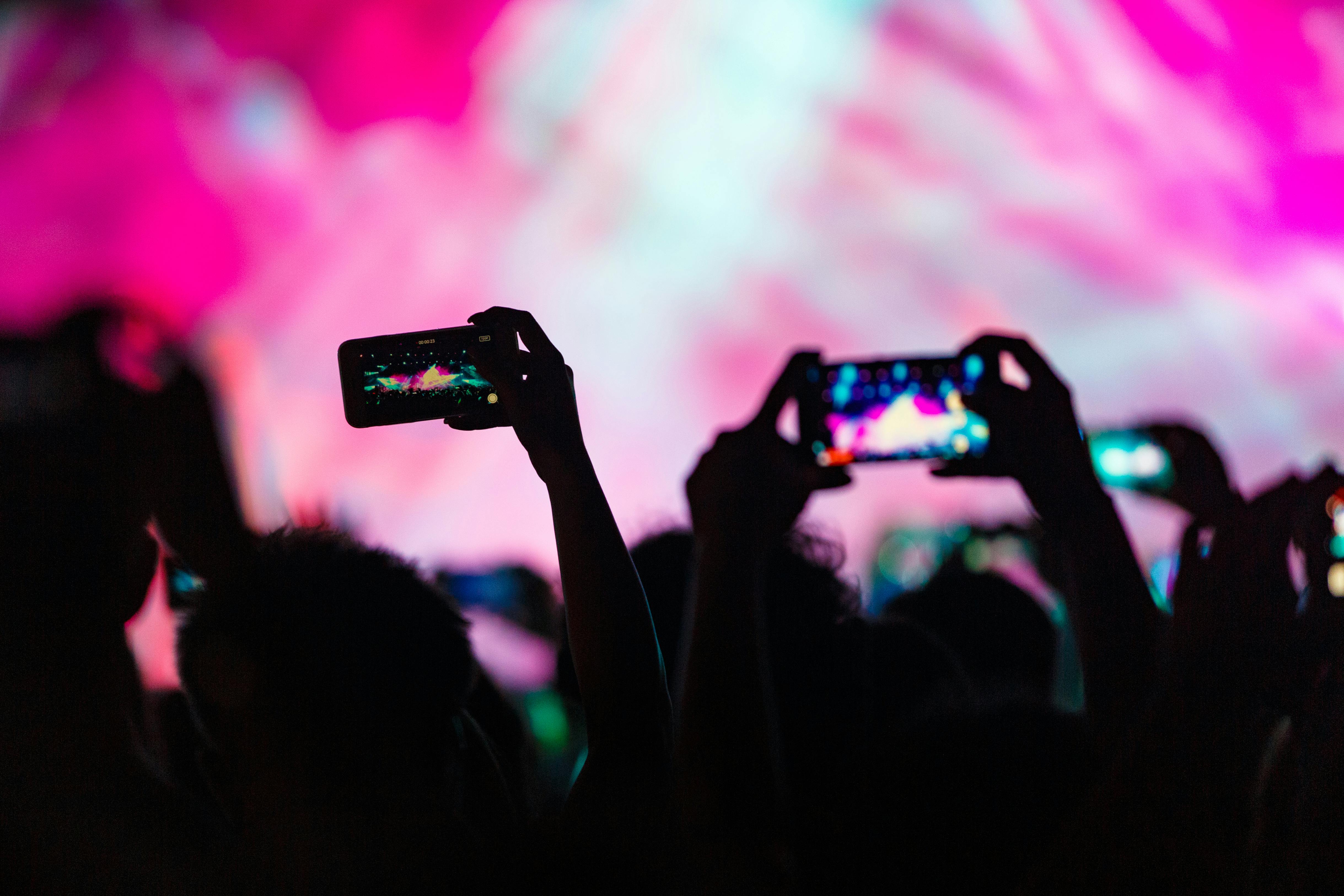 Des personnes tenant leur téléphone pour enregistrer et prendre des photos | Source : Pexels
