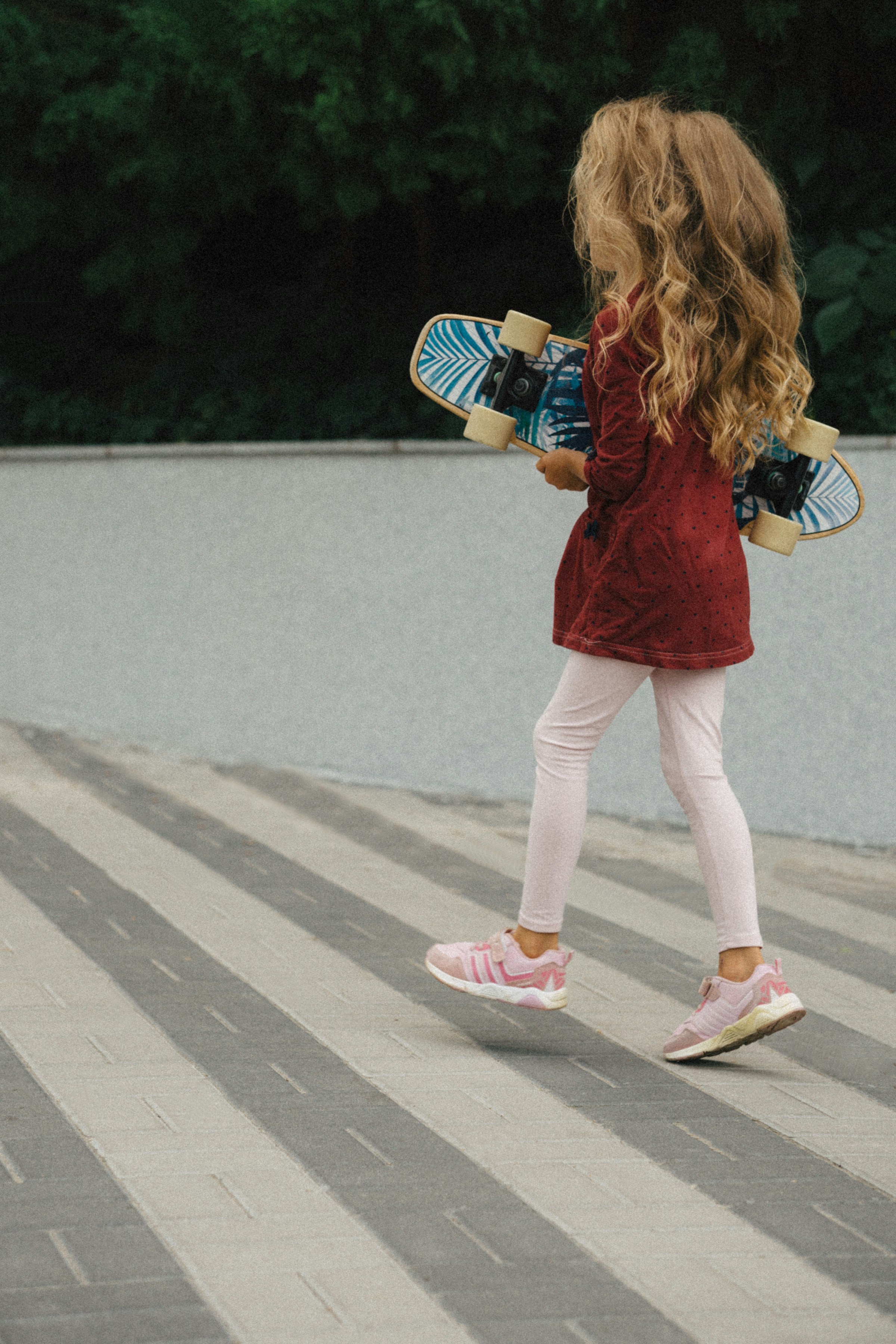 Une petite fille tenant un skateboard | Source : Unsplash