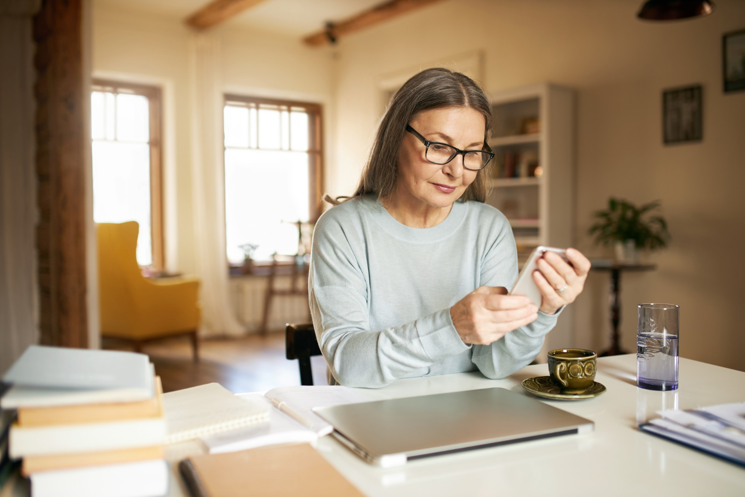 Une femme âgée anxieuse tenant son téléphone | Source : Freepik