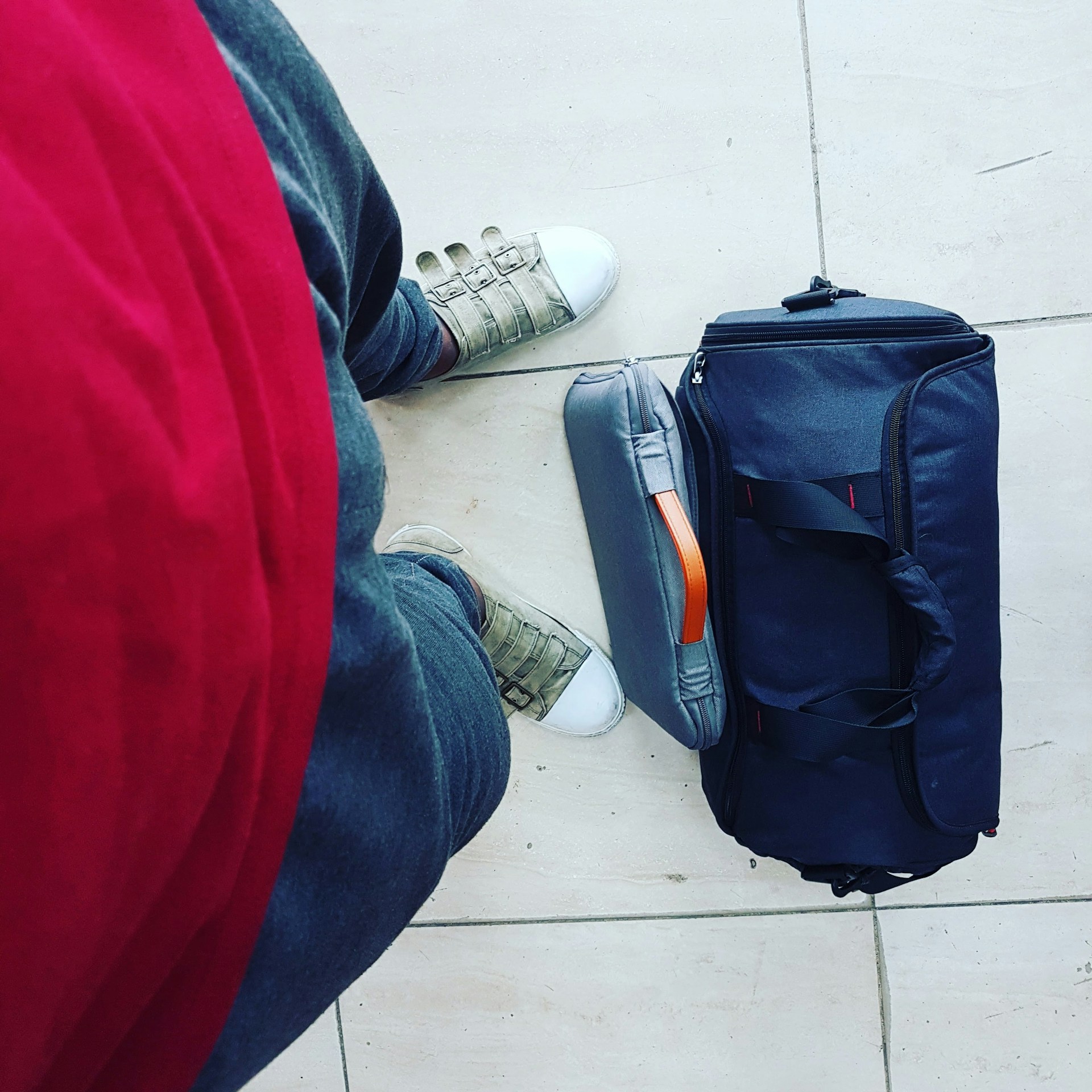 Un sac de voyage aux pieds de quelqu'un | Source : Unsplash