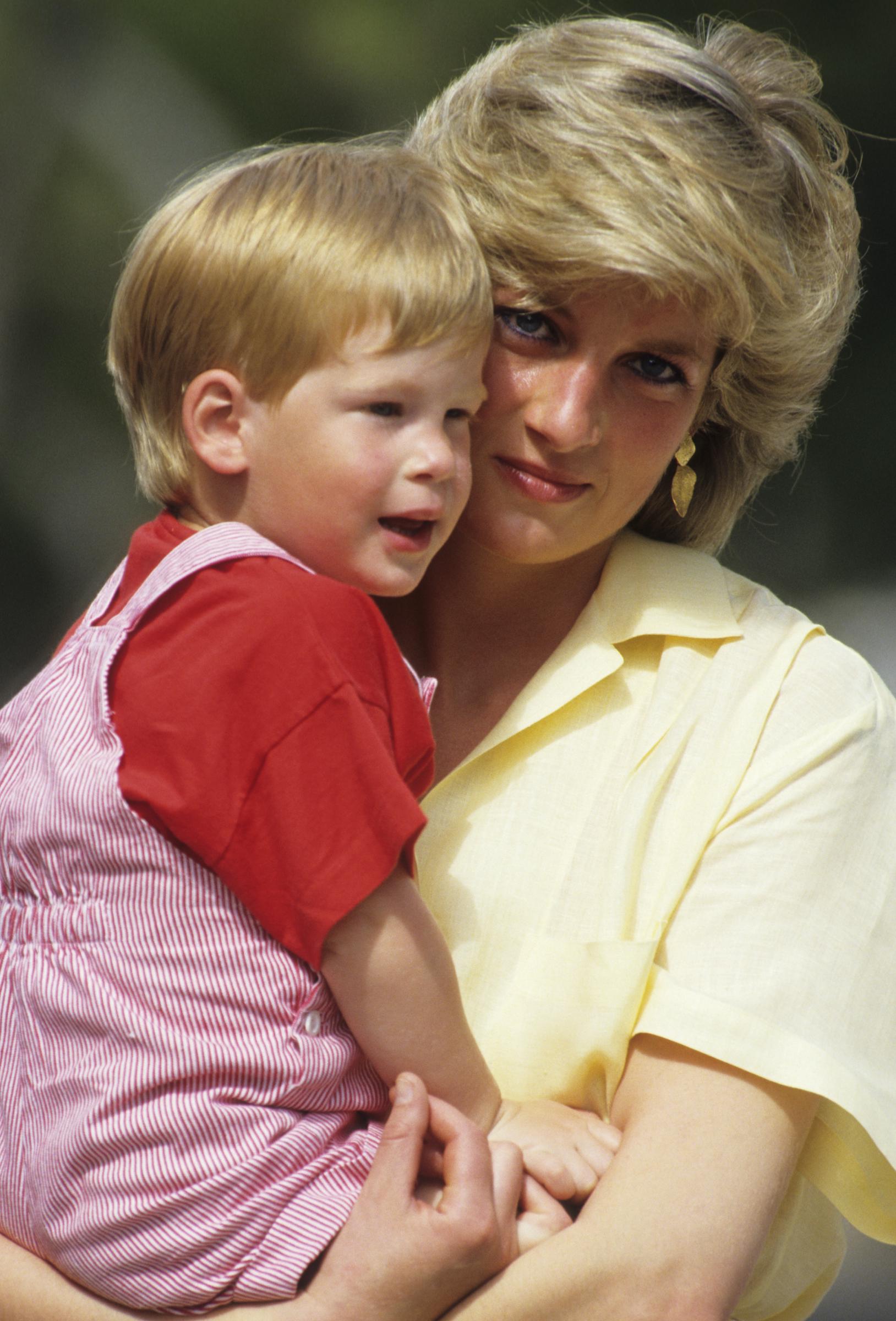 La princesse Diana tient dans ses bras le jeune prince Harry lors de vacances en famille à Majorque, en Espagne, en août 1987. Des décennies plus tard, une source a déclaré que l'héritage de Diana continuait d'influencer Harry alors que les tensions avec la famille royale persistent. | Source : Getty Images