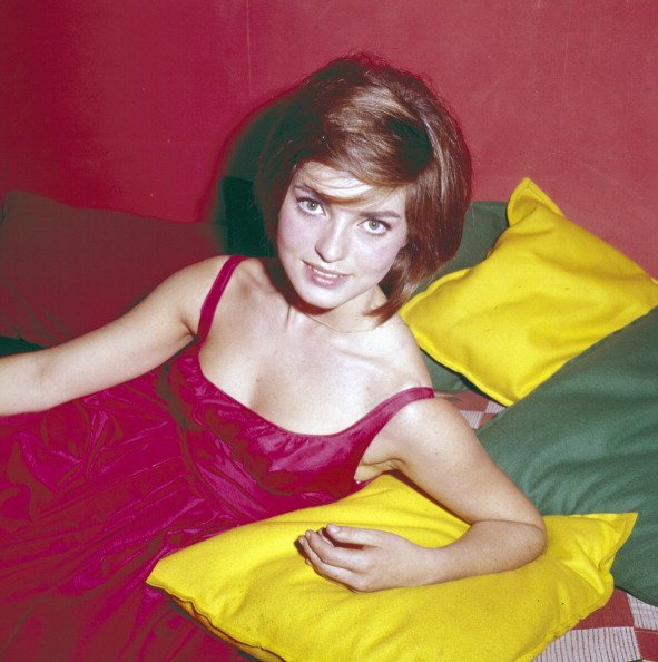 L'actrice française Marie-France Pisier (1944-2011) pose entourée de coussins en 1962. | Photo : Getty Images
