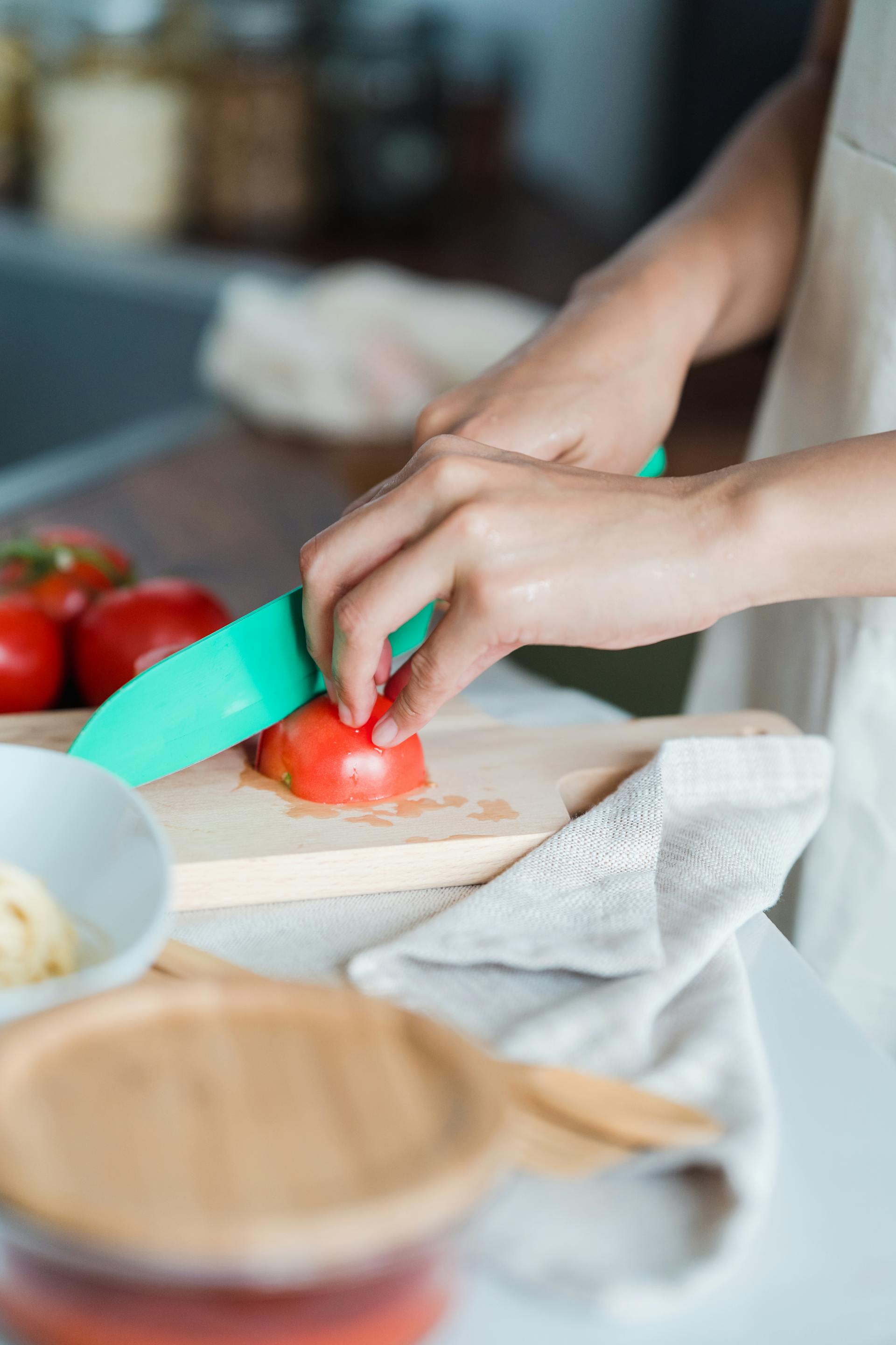 Une personne qui coupe des tomates en tranches | Source : Pexels