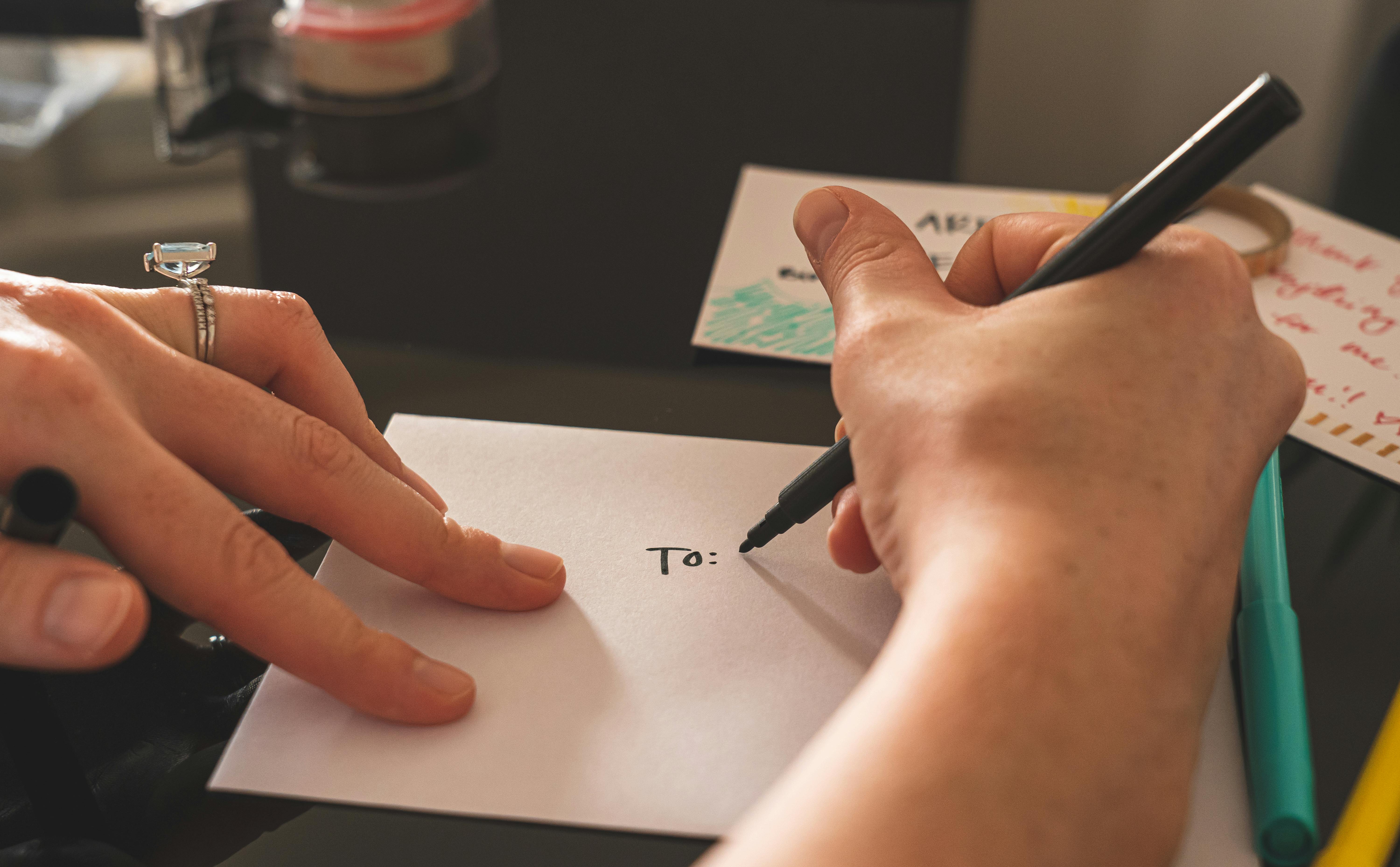 Une personne qui écrit sur une enveloppe | Source : Pexels
