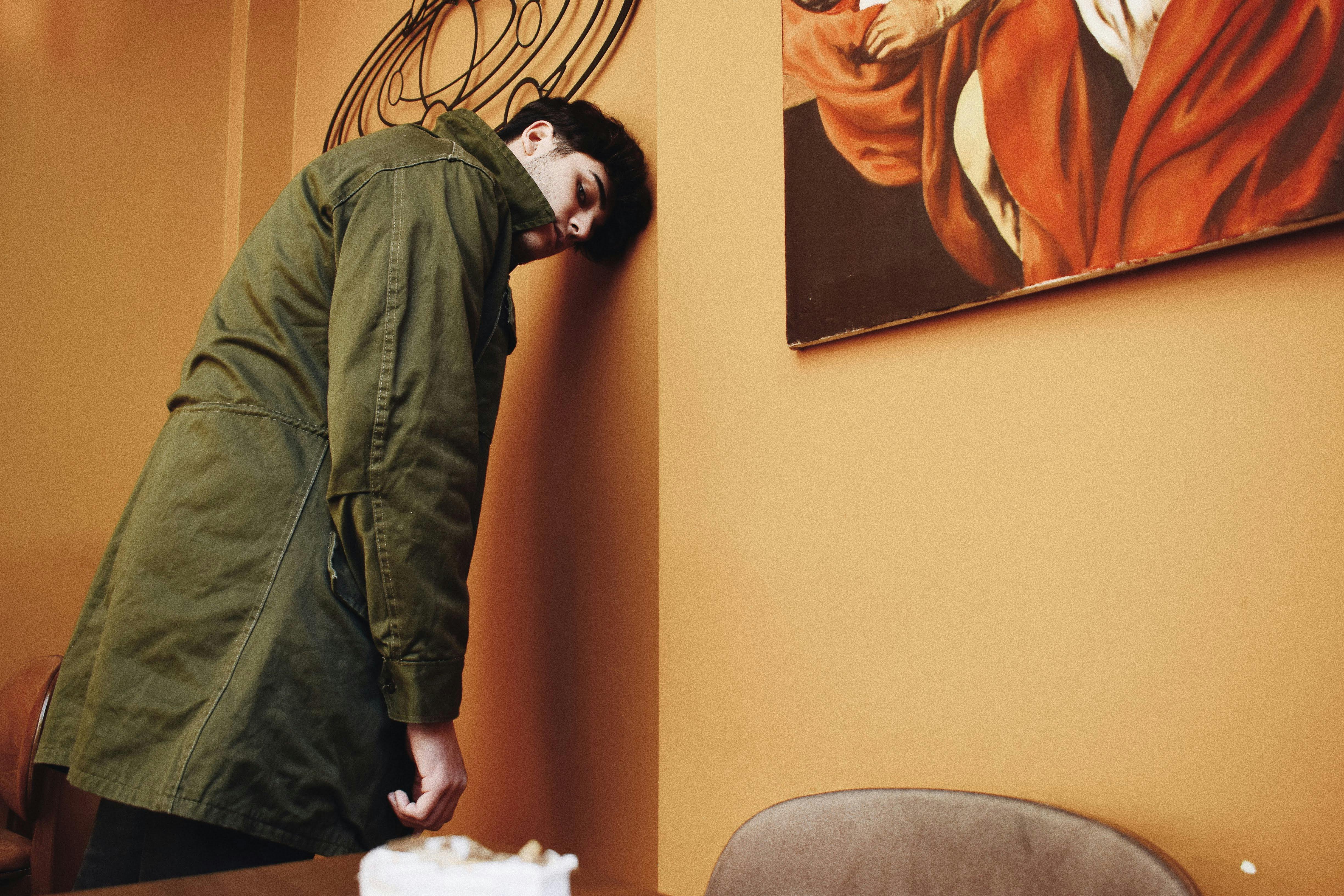 Un homme épuisé adossé à un mur | Source : Pexels