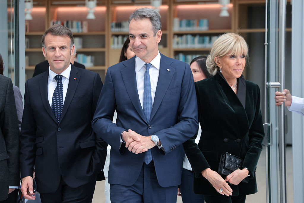Le président français Emmanuel Macron (à gauche), son épouse Brigitte Macron (à droite) et le Premier ministre grec Kyriakos Mitsotakis quittent le Centre culturel de la Fondation Stavros Niarchos à Athènes après avoir visité une exposition, le 25 avril 2026 I Source : Getty Images