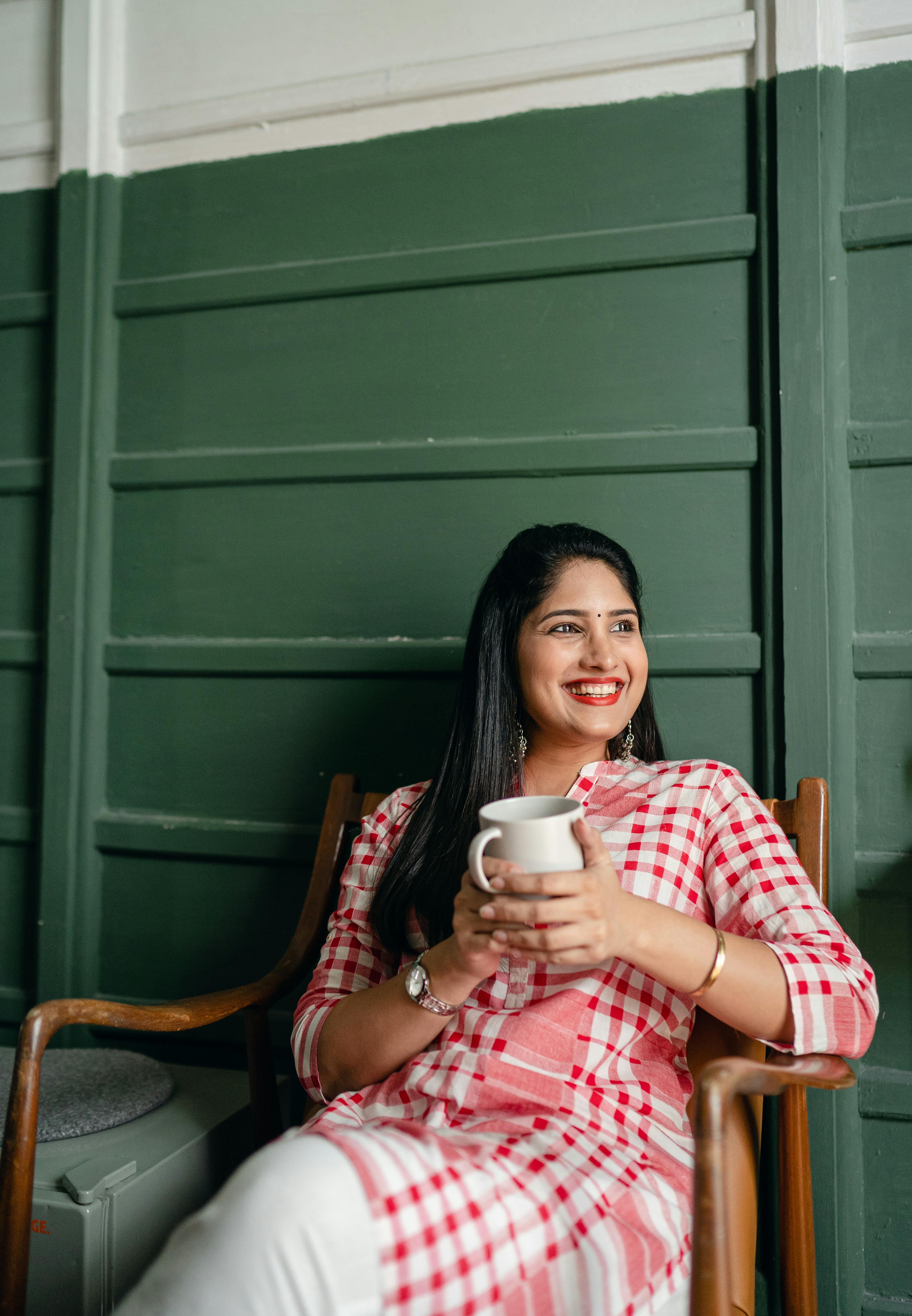 Une femme heureuse tenant une tasse | Source : Pexels