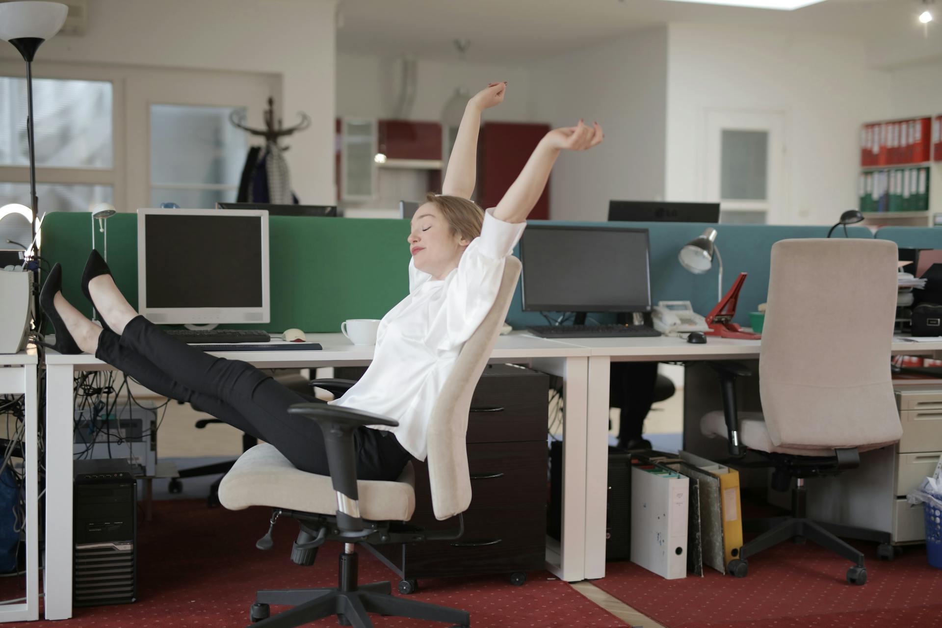 Une employée de bureau se détend avec ses pieds sur la table | Source : Pexels
