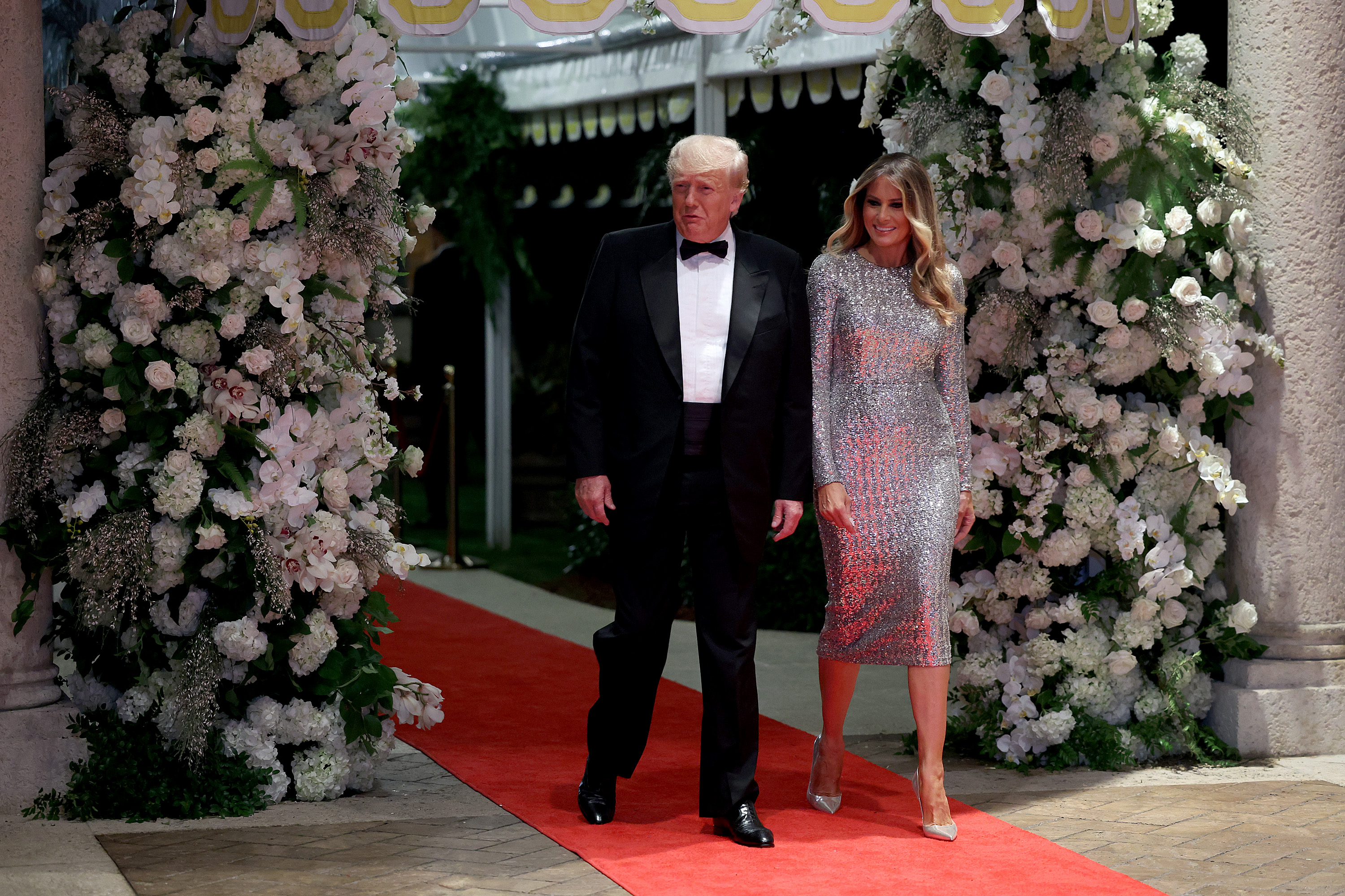 Melania Trump arrive pour fêter le réveillon du Nouvel An à Mar-a-Lago, à Palm Beach, en Floride, le 31 décembre 2022, vêtue d'une robe mi-longue argentée à paillettes scintillantes, assortie d'escarpins à bout pointu argentés réfléchissants dont les talons fins comme des aiguilles allongent sa silhouette de soirée.