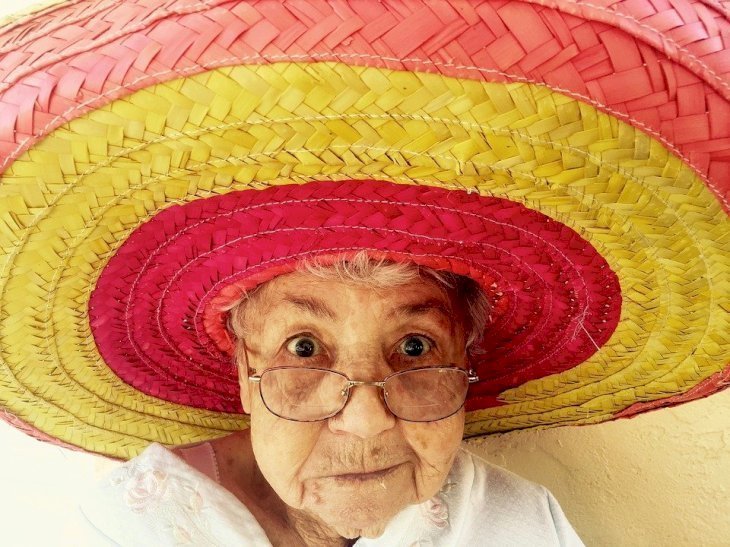 Une dame heureuse dans un chapeau coloré. | Source : Pixabay