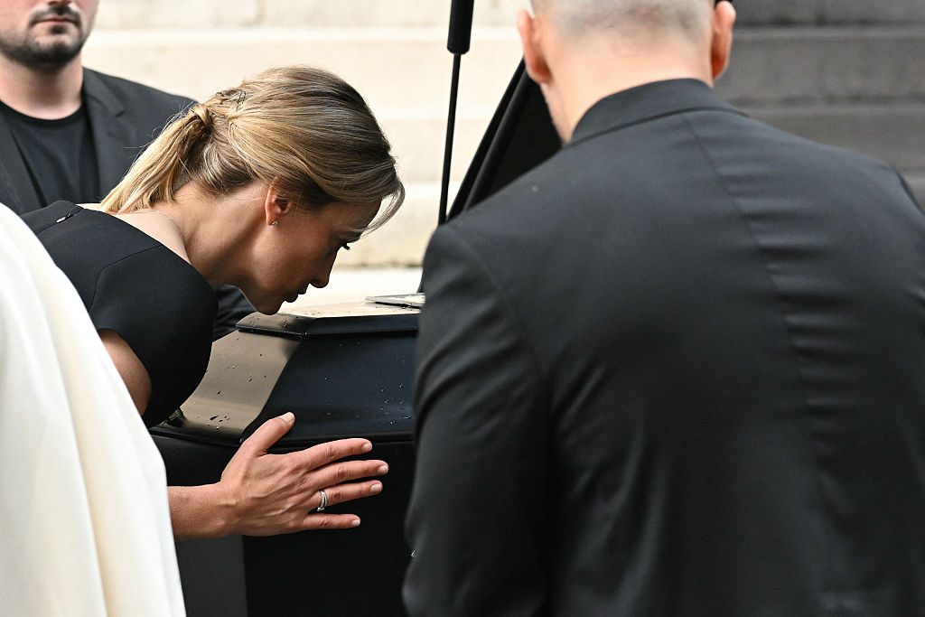 Audrey Crespo-Mara embrassant le cercueil de Thierry Ardisson à la fin de ses funérailles à l'église Saint-Roch à Paris | Source : Getty Images