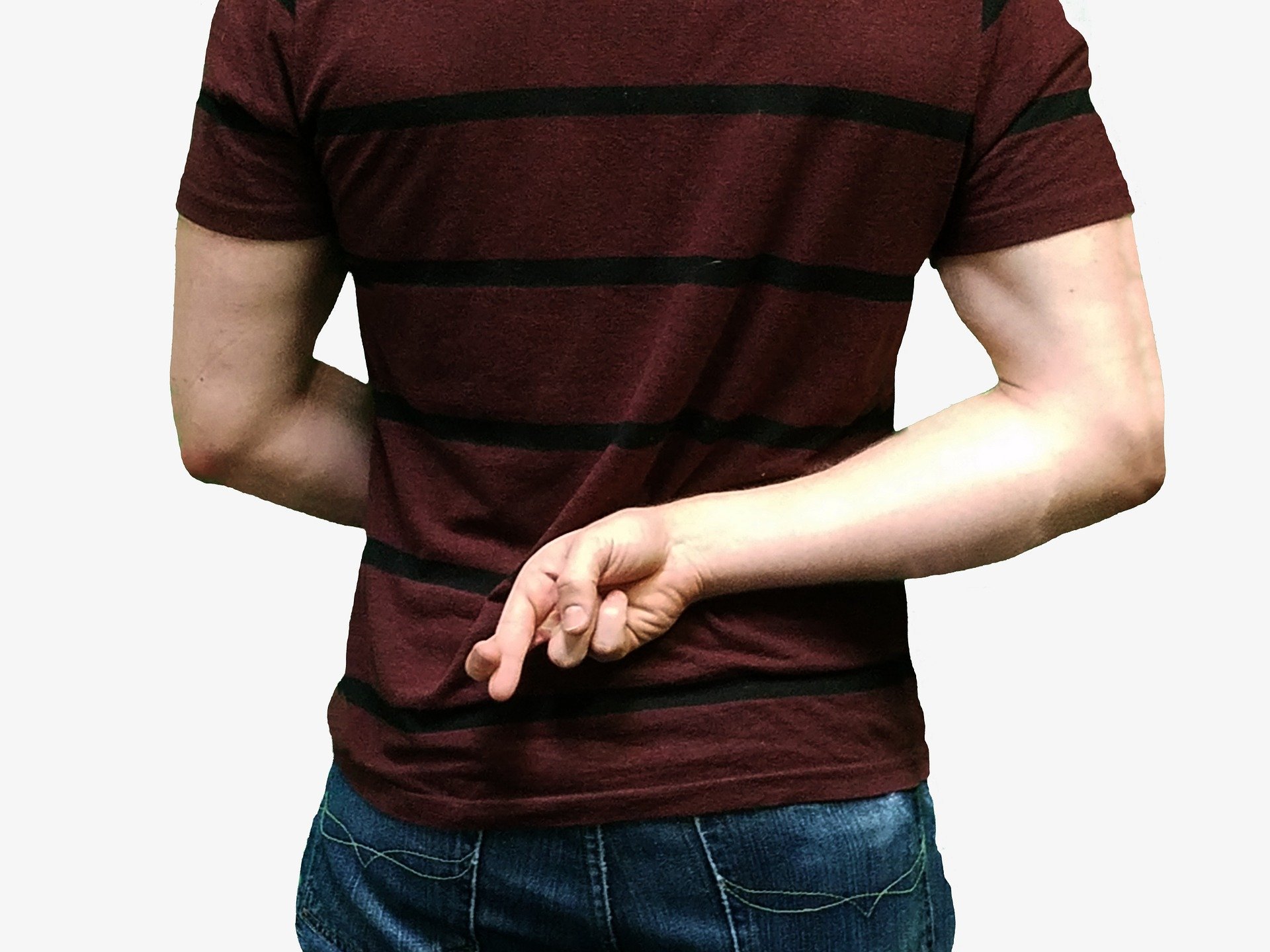 Un homme avec les doigts croisés derrière le dos.  | Photo : Pixabay
