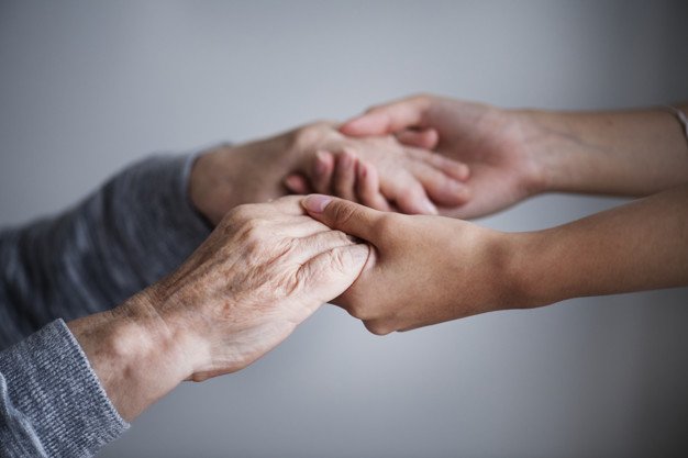 Les jeunes mains tiennent les mains d'une personne plus âgée. | Source : Freepik
