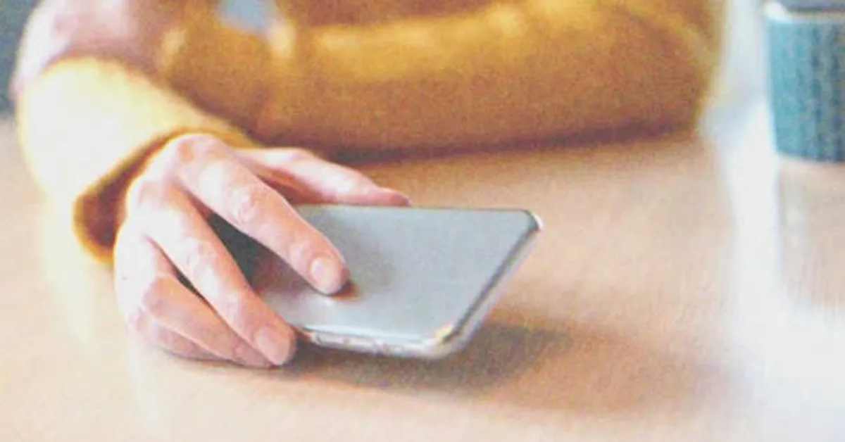 Gros plan d'une main tenant un téléphone portable | Source : Shutterstock