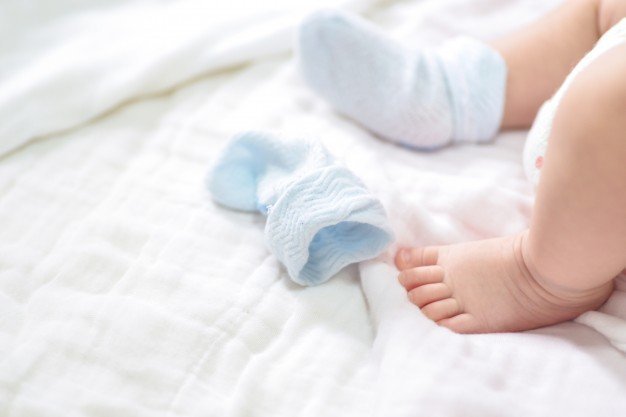 Pied d'un bébé avec une seule chaussette | Photo : Freepik