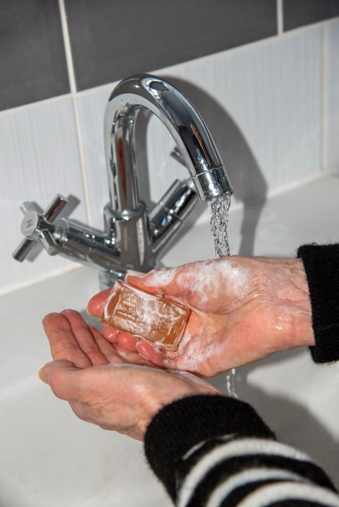 Une femme en train de sa laver les mains. | Photo : Getty Images