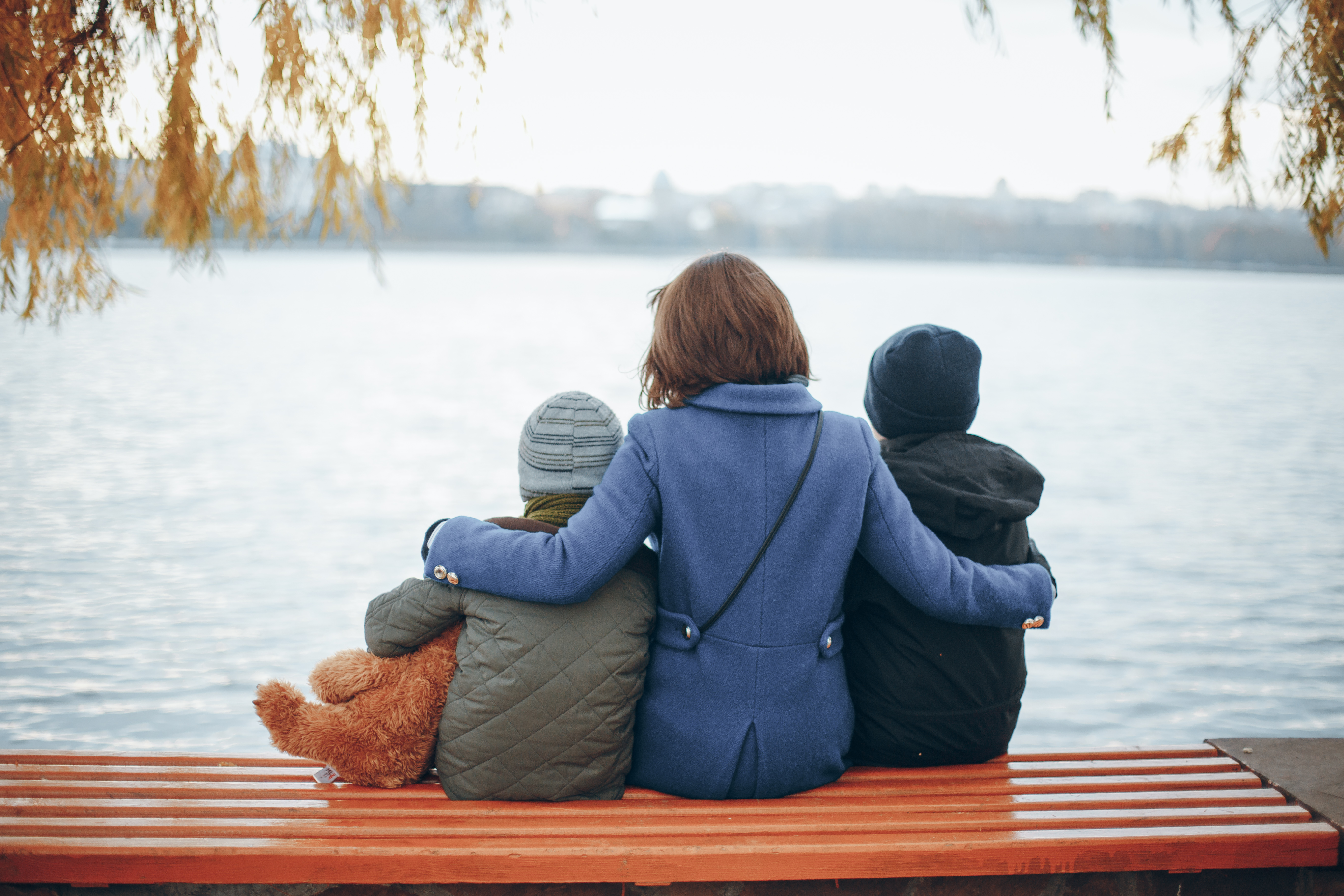Une femme assise sur un banc avec deux enfants | Source : Shutterstock
