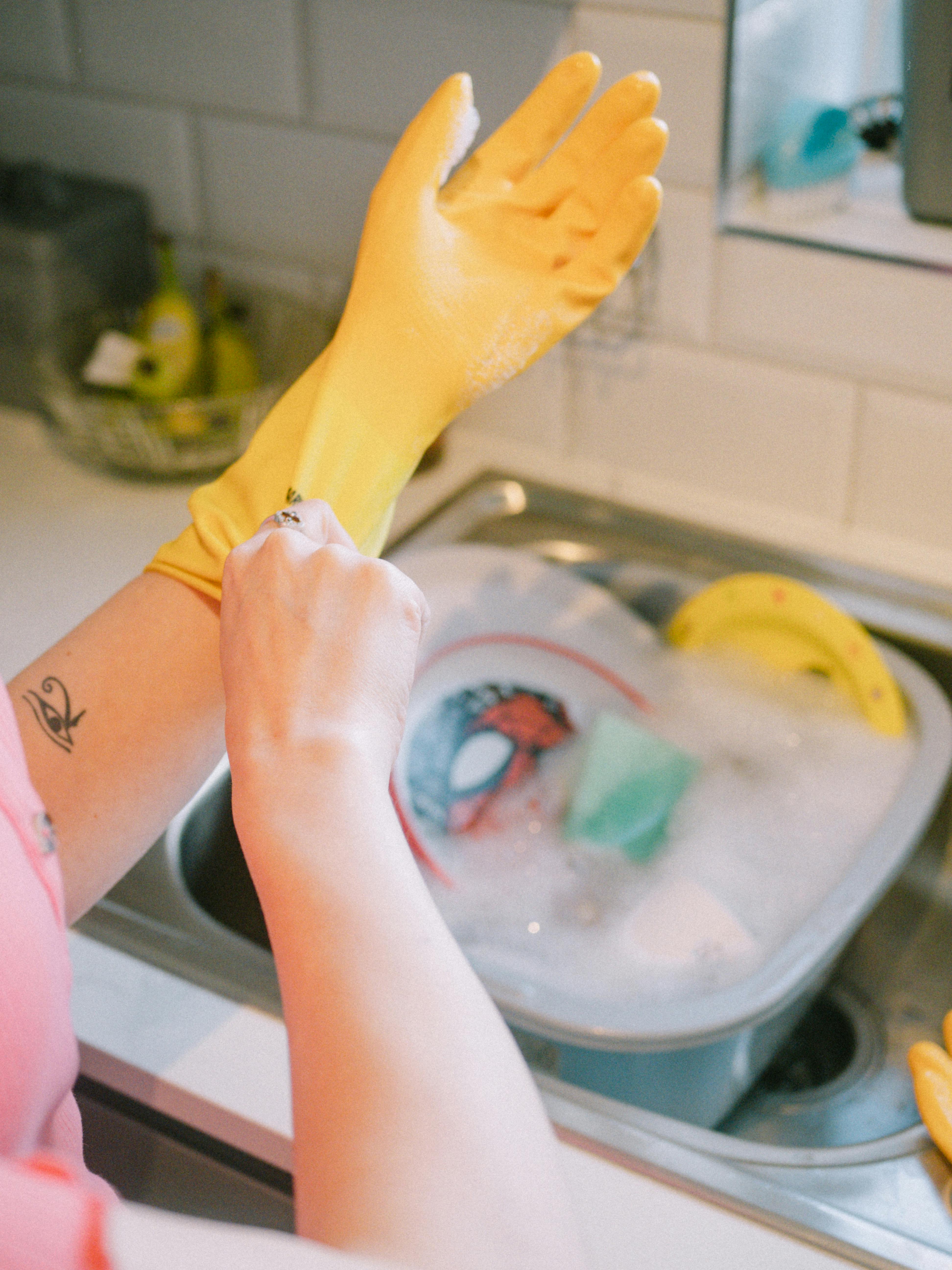 Une femme portant des gants prête à faire la vaisselle | Source : Pexels