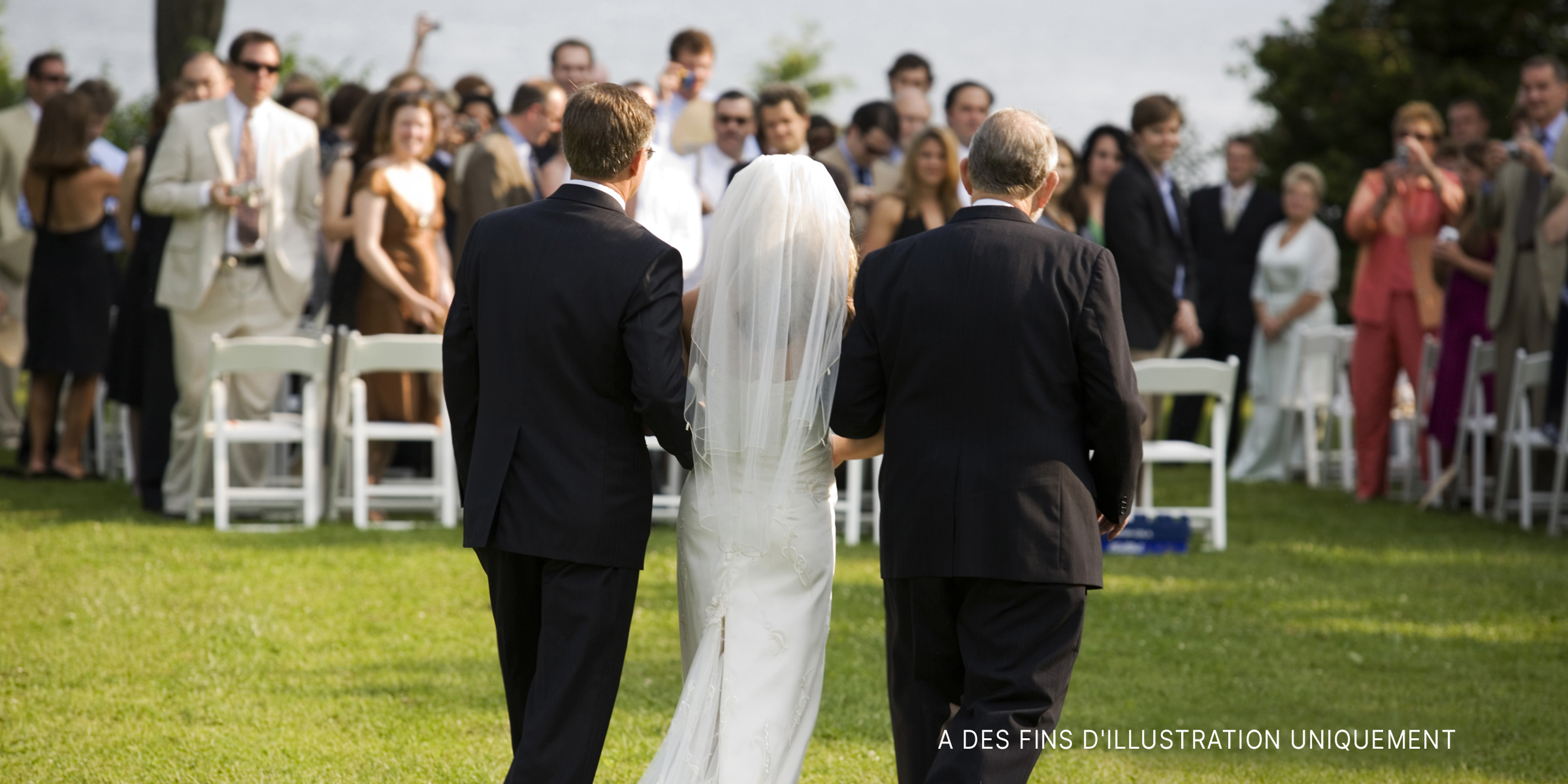 Une mariée conduite à l'autel par deux hommes | Source : Getty Images