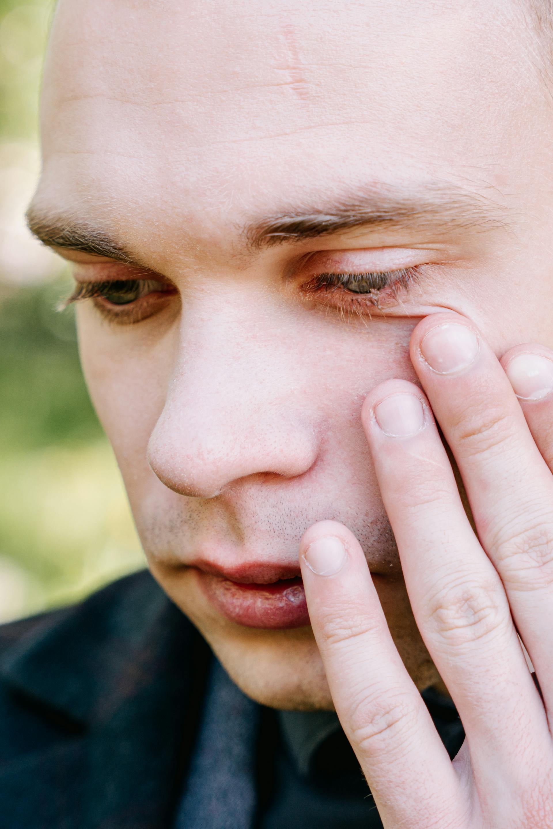 Homme essuyant ses larmes | Source : Pexels