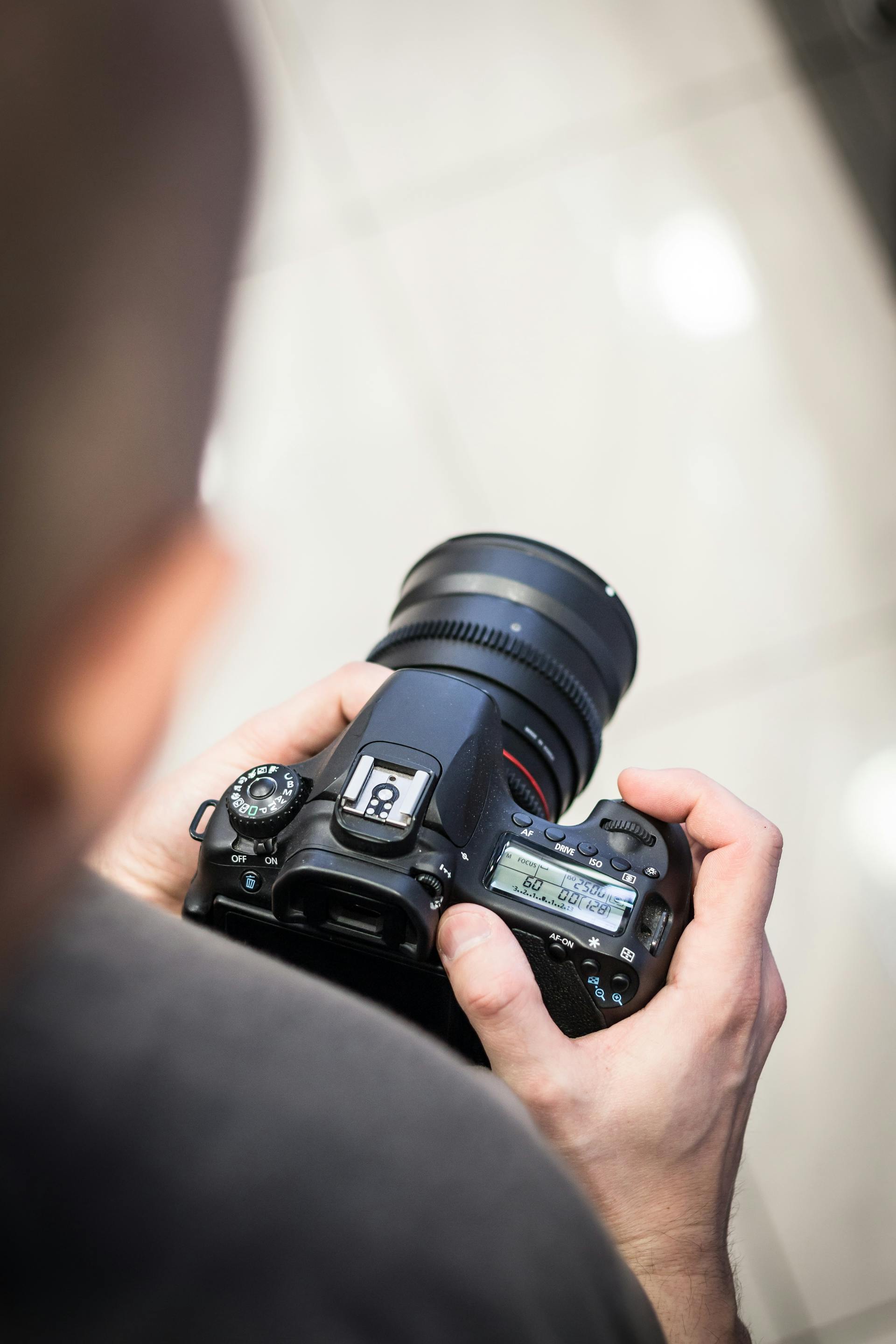 Un homme tenant un appareil photo reflex numérique | Source : Pexels