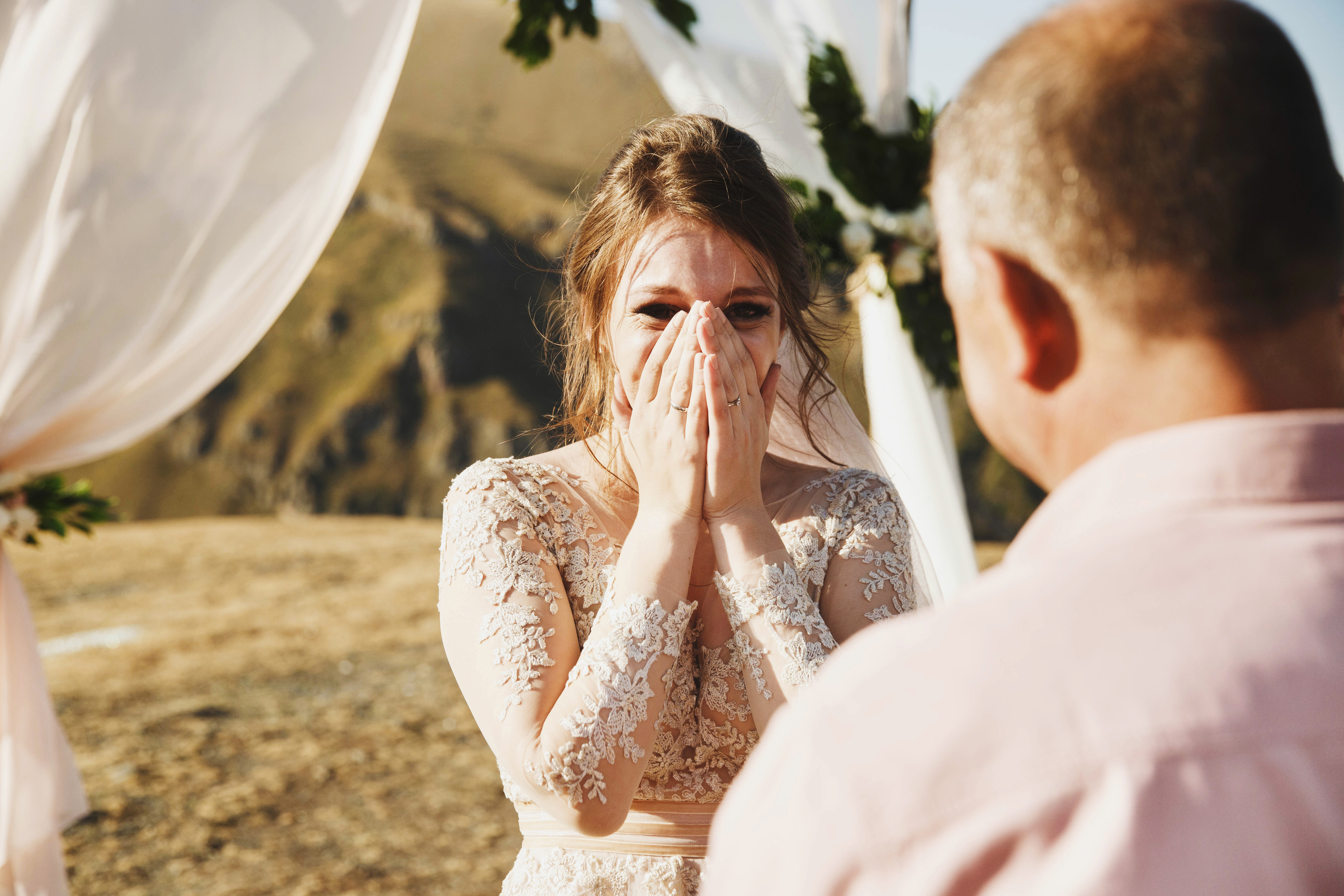 Une mariée regarde son père avec ses mains couvrant sa bouche | Source : Shutterstock