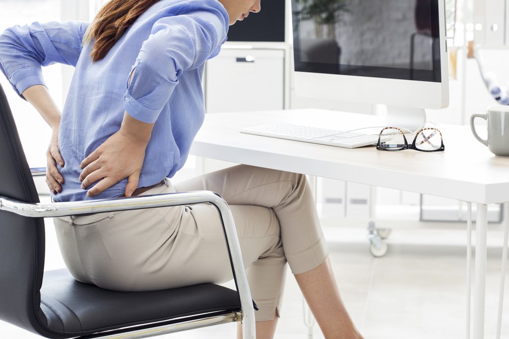 Une femme assise avec un mal de dos. l Source: Shutterstock