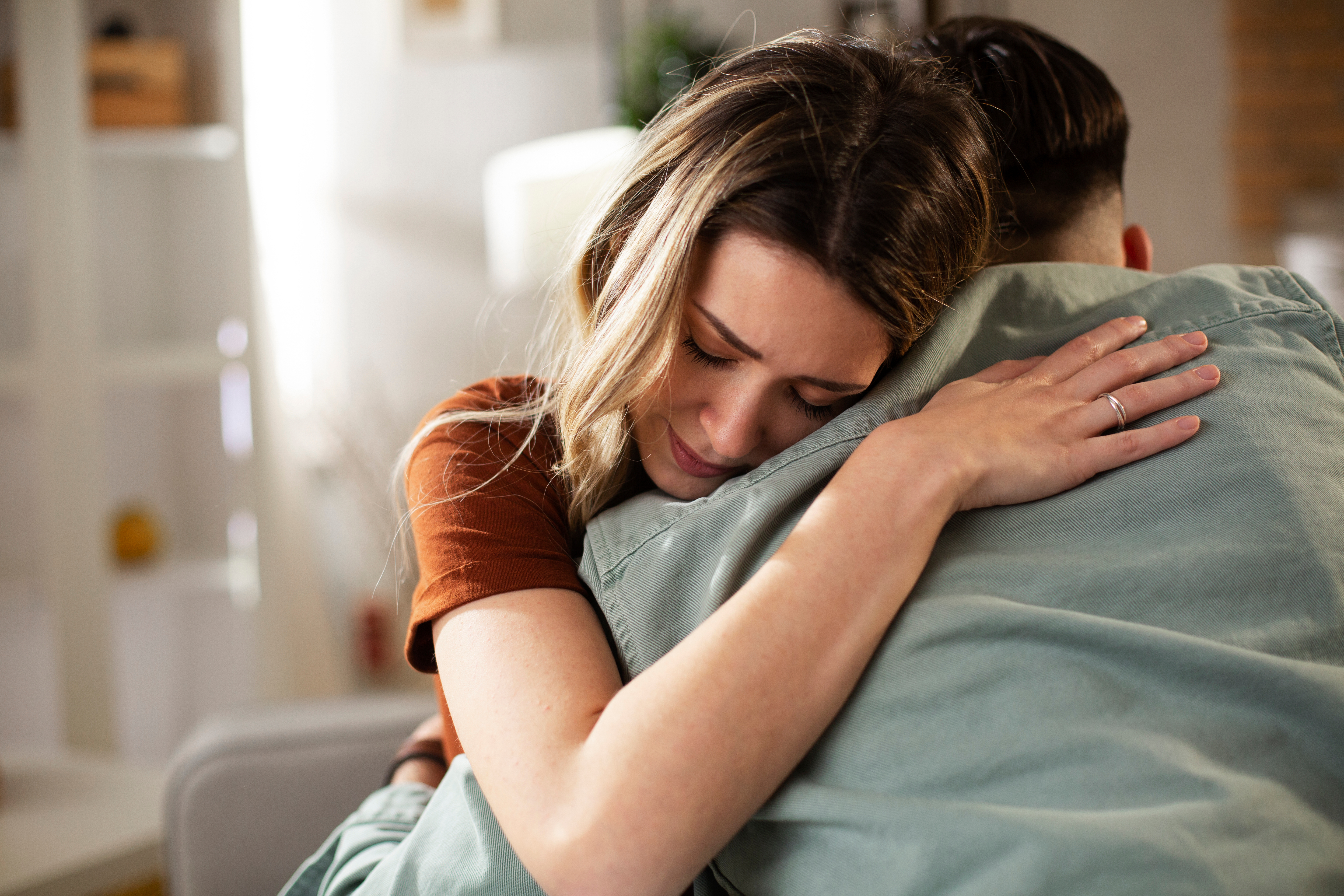 Un homme réconforte sa femme triste en la prenant dans ses bras | Source : Shutterstock