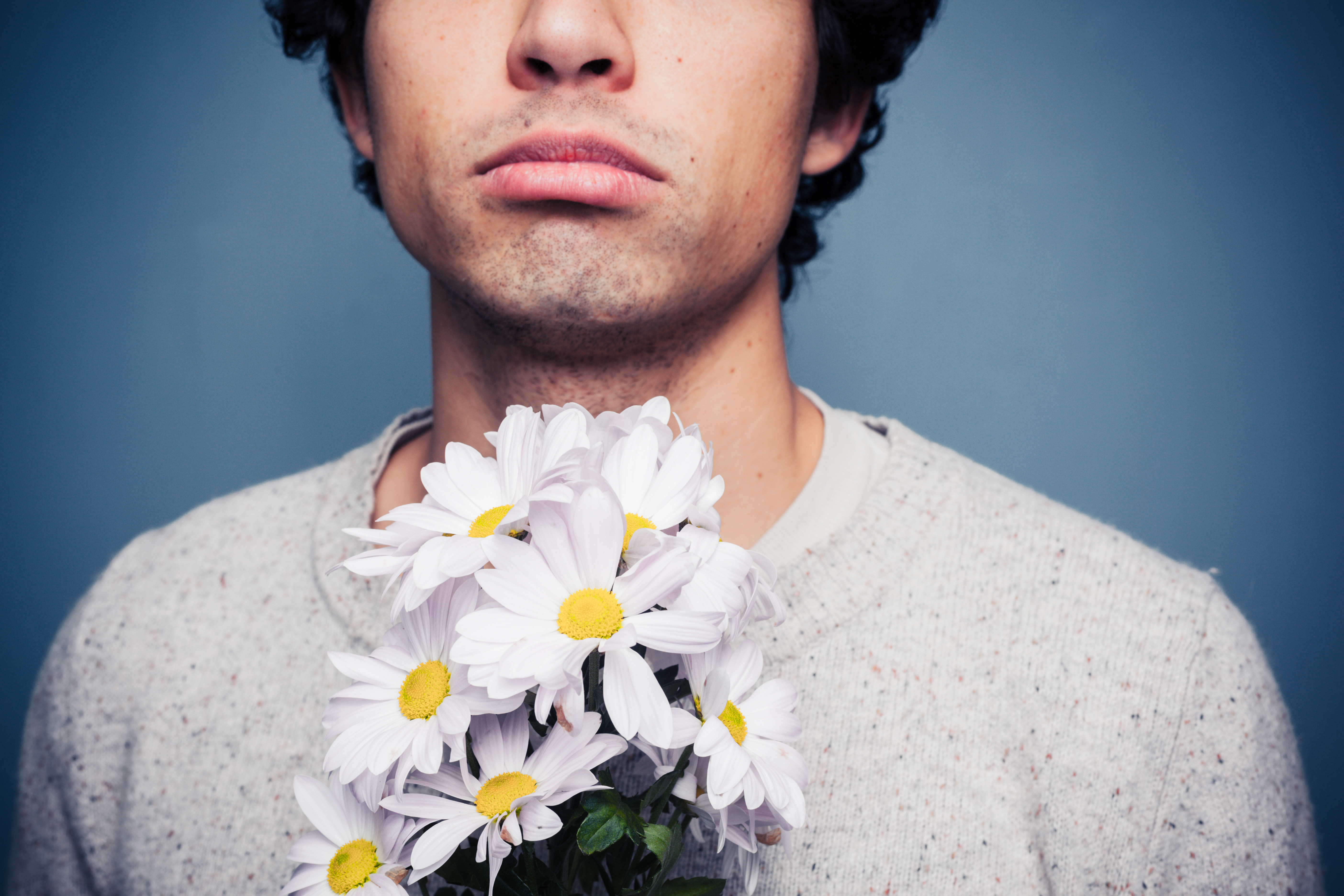 Un homme tenant des fleurs | Source : Shutterstock