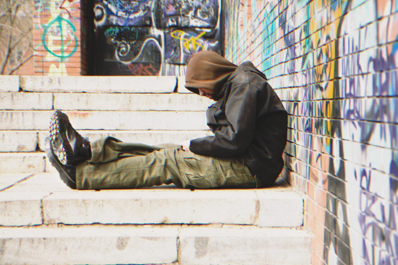 Un sans abri assis dans la rue | Source : Shutterstock